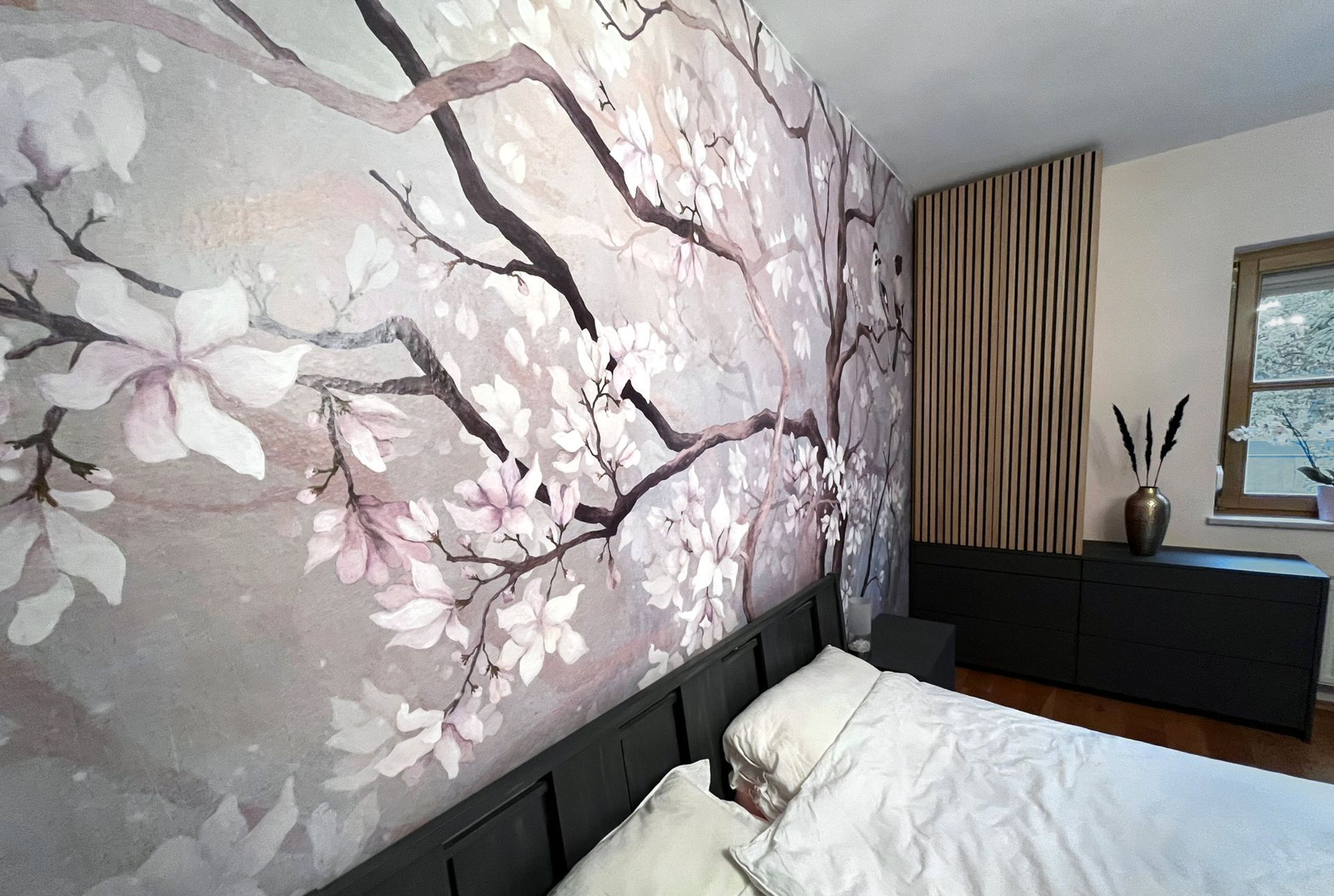 Interiordesign eines Schlafzimmers, zentrale Designtapete mit Blütenranken und Lamellenschrank