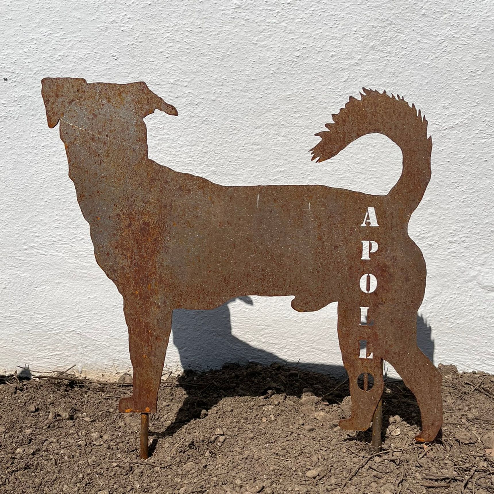 Rostige Metall-Hunde-Gartenfigur mit ausgeschnittenem Namen „APOLL“.