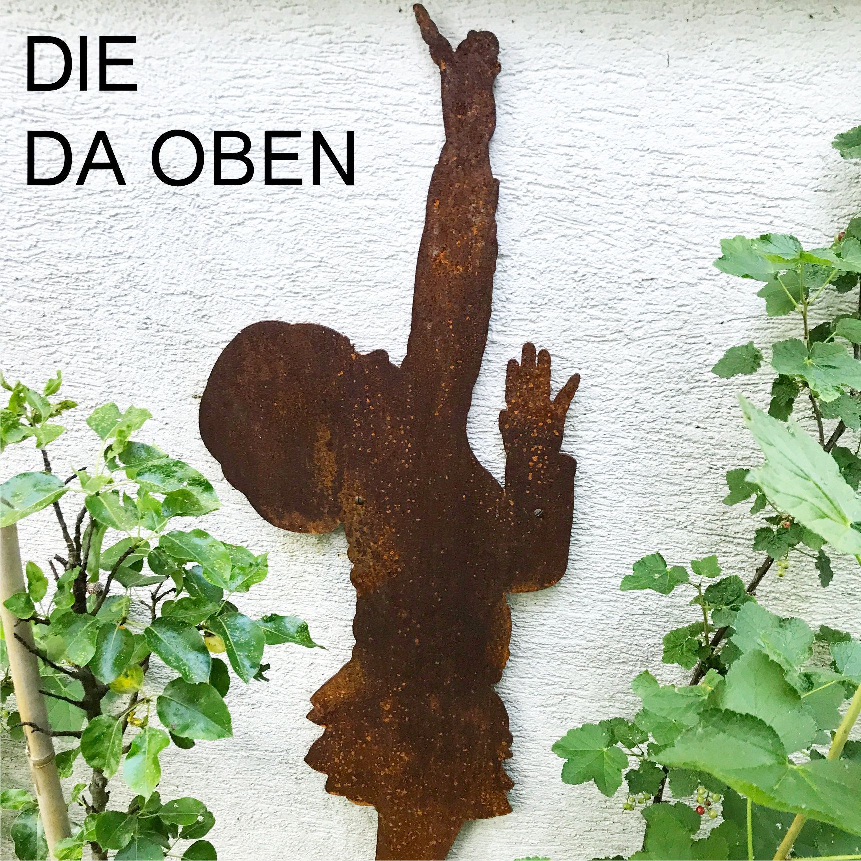 Rostige Metallsilhouette einer nach oben greifenden Person, angebracht an einer weißen Wand; 