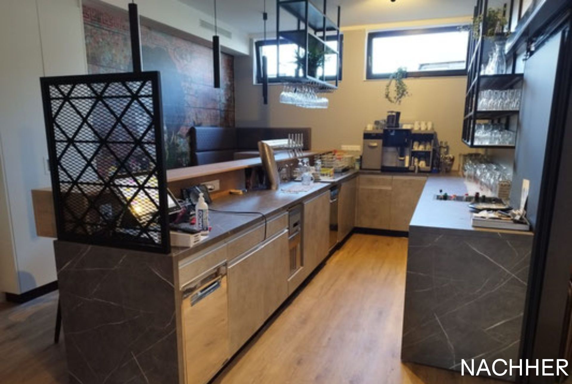 Bar mit Theken aus Holz und Marmor, Regalen mit Gläsern und einem dekorativen Paravent.