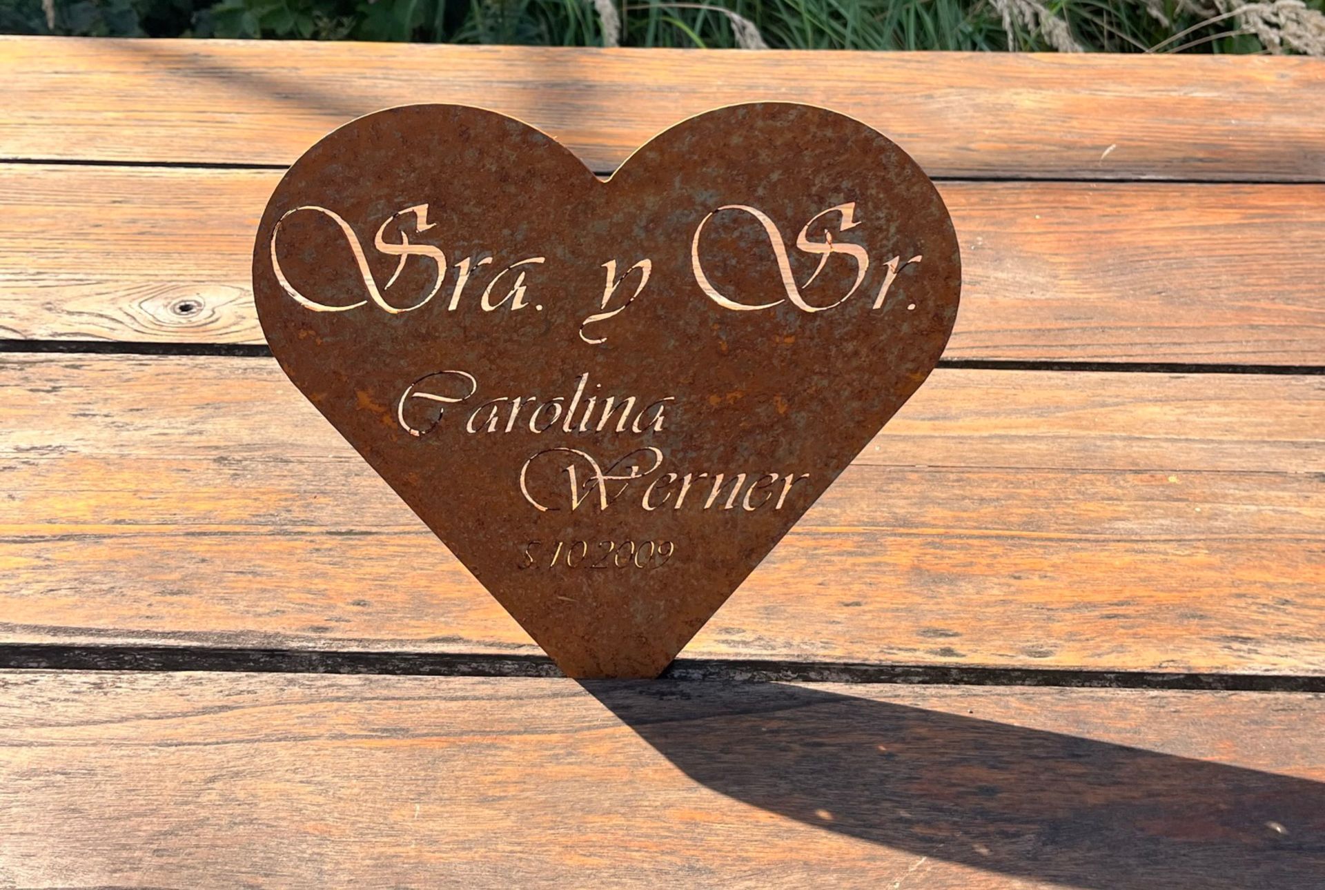Herzförmige Metallplakette mit der Aufschrift: „Sra. y Sr. Carolina Werner“. 