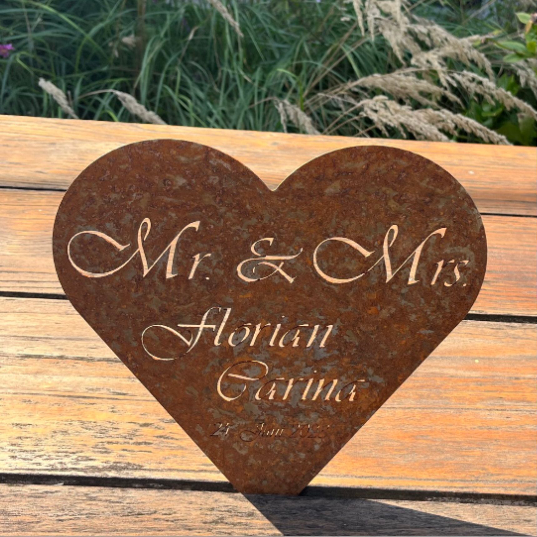 Rustikales, herzförmiges Schild mit der Aufschrift „Mr. & Mrs. Florian Garvus“. 