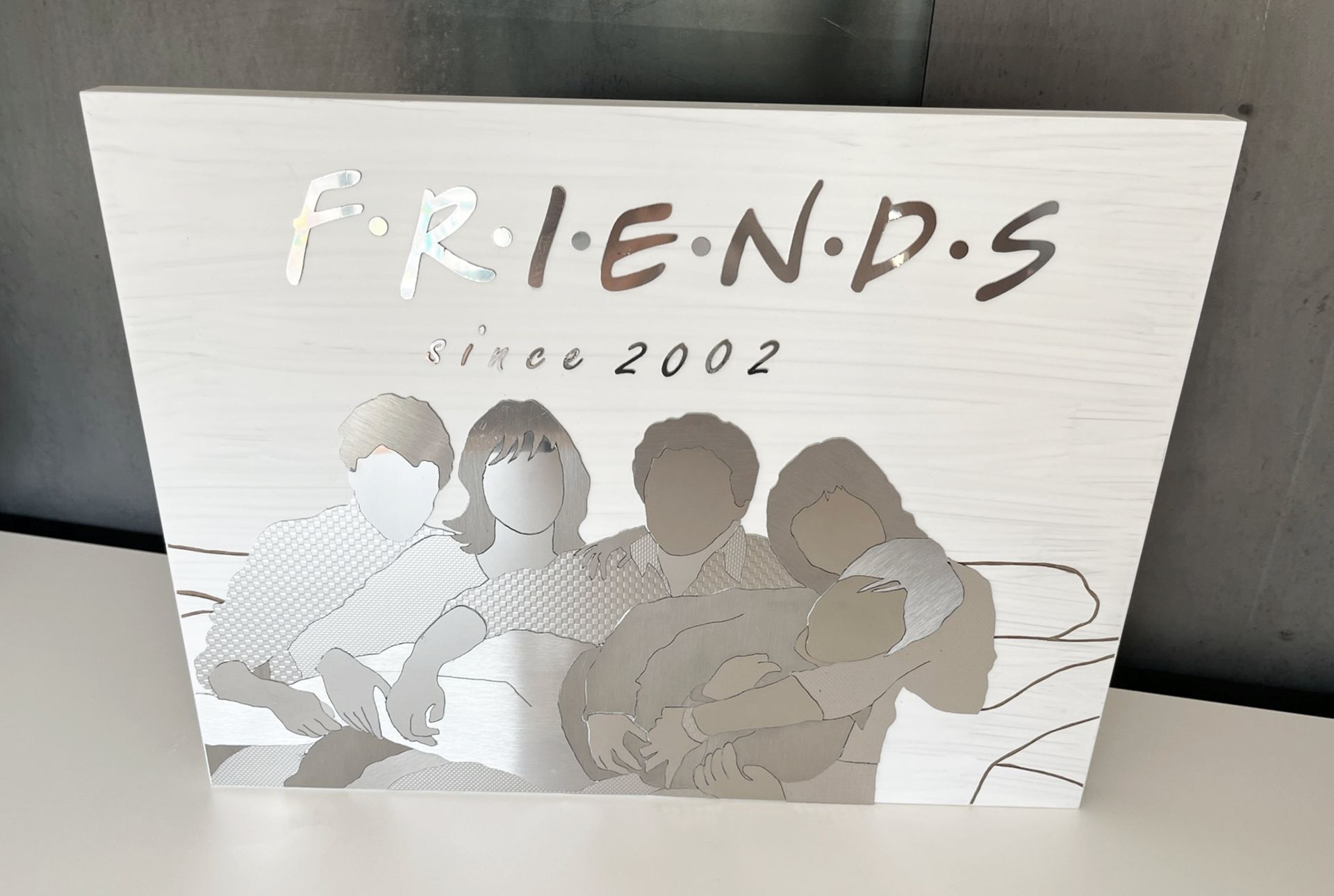 Ein Kunstwerk im Friends-Stil mit vier verschwommenen Figuren unter dem Logo der Serie. 