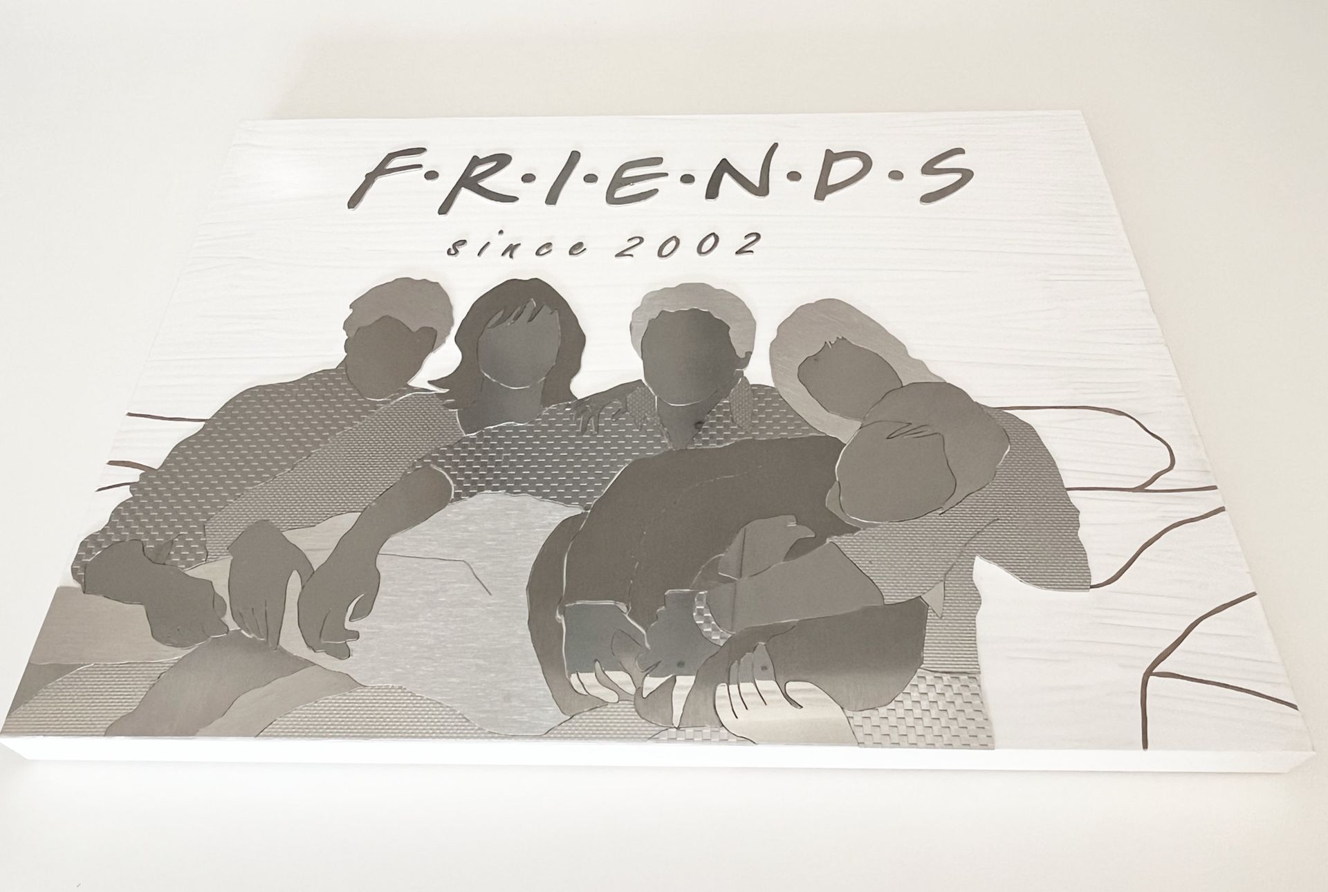 Das „Friends“-Logo auf weißem Grund. Silhouetten von vier Personen auf einem Sofa. Unter dem Logo steht „since 2007“.
