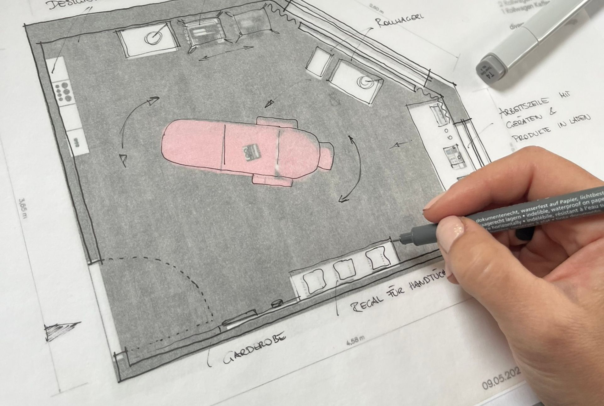Handzeichnung eines Grundrisses eines Zimmers mit einer rosa Massageliege unter Verwendung von Markern und Zeichenwerkzeugen.