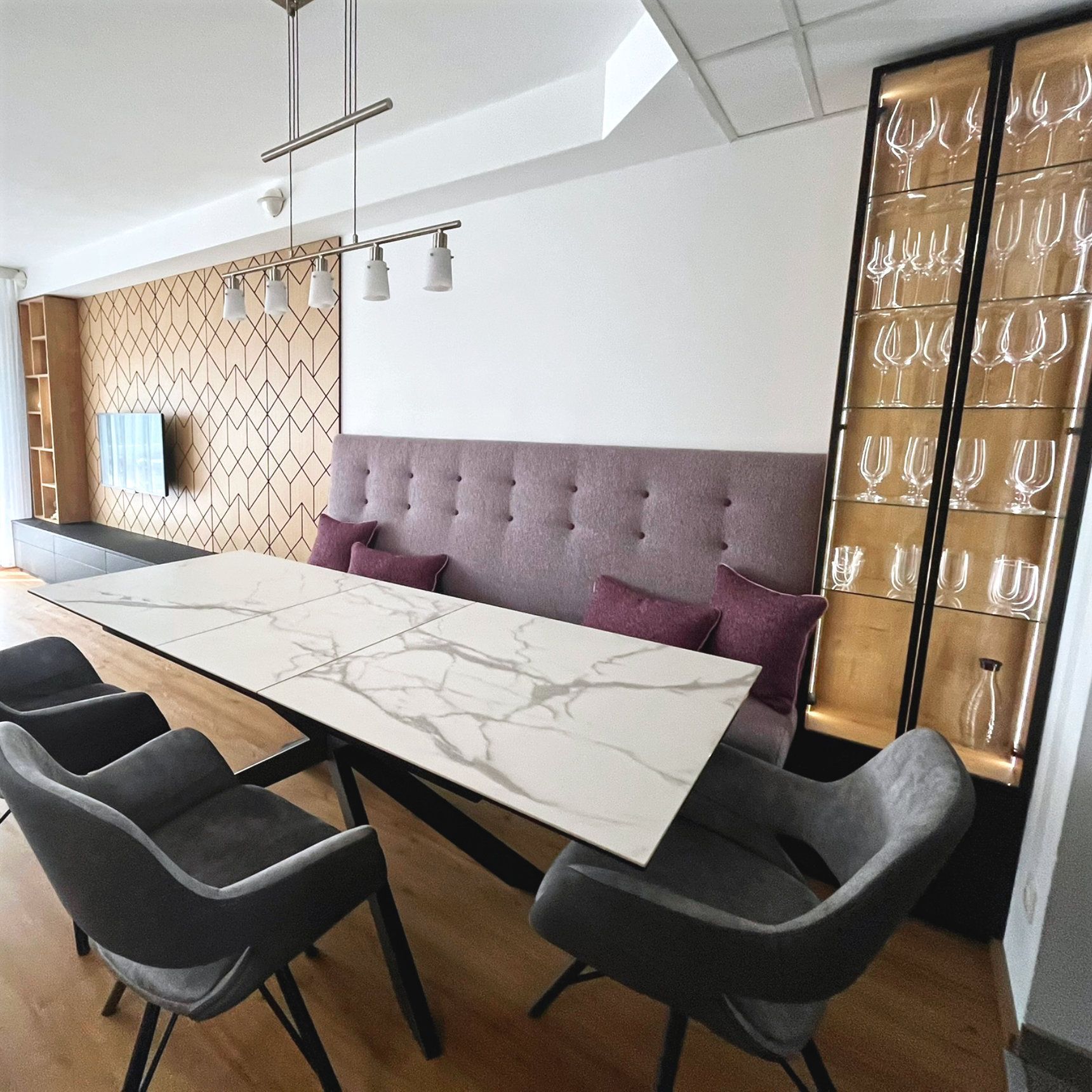 Moderner Essbereich mit Sitzbank und beleuchteter Vitrine wie im Café