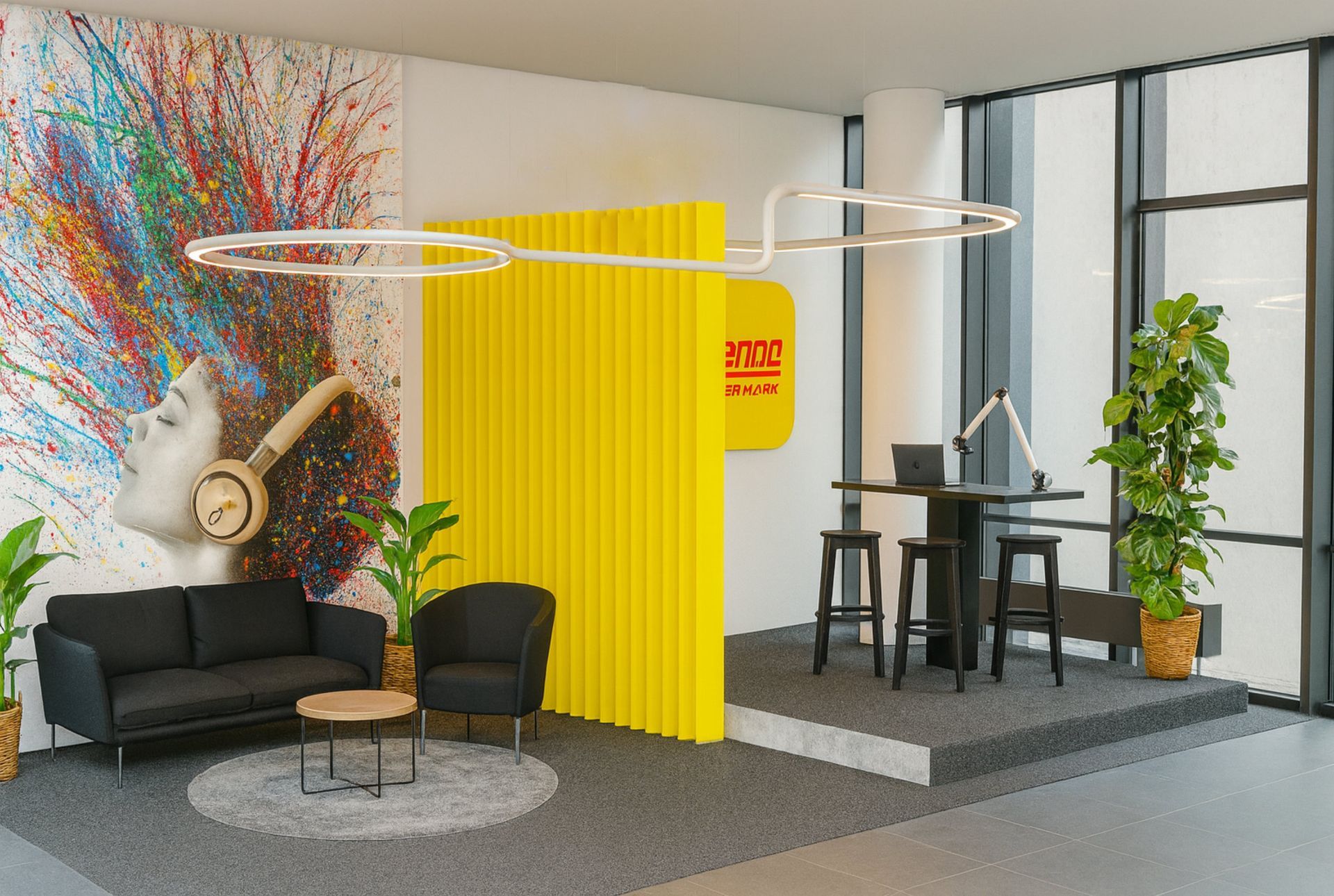 Modernes Bürointerieur mit gelben Akzenten, einer Sitzecke und einem erhöhten Arbeitsplatz.