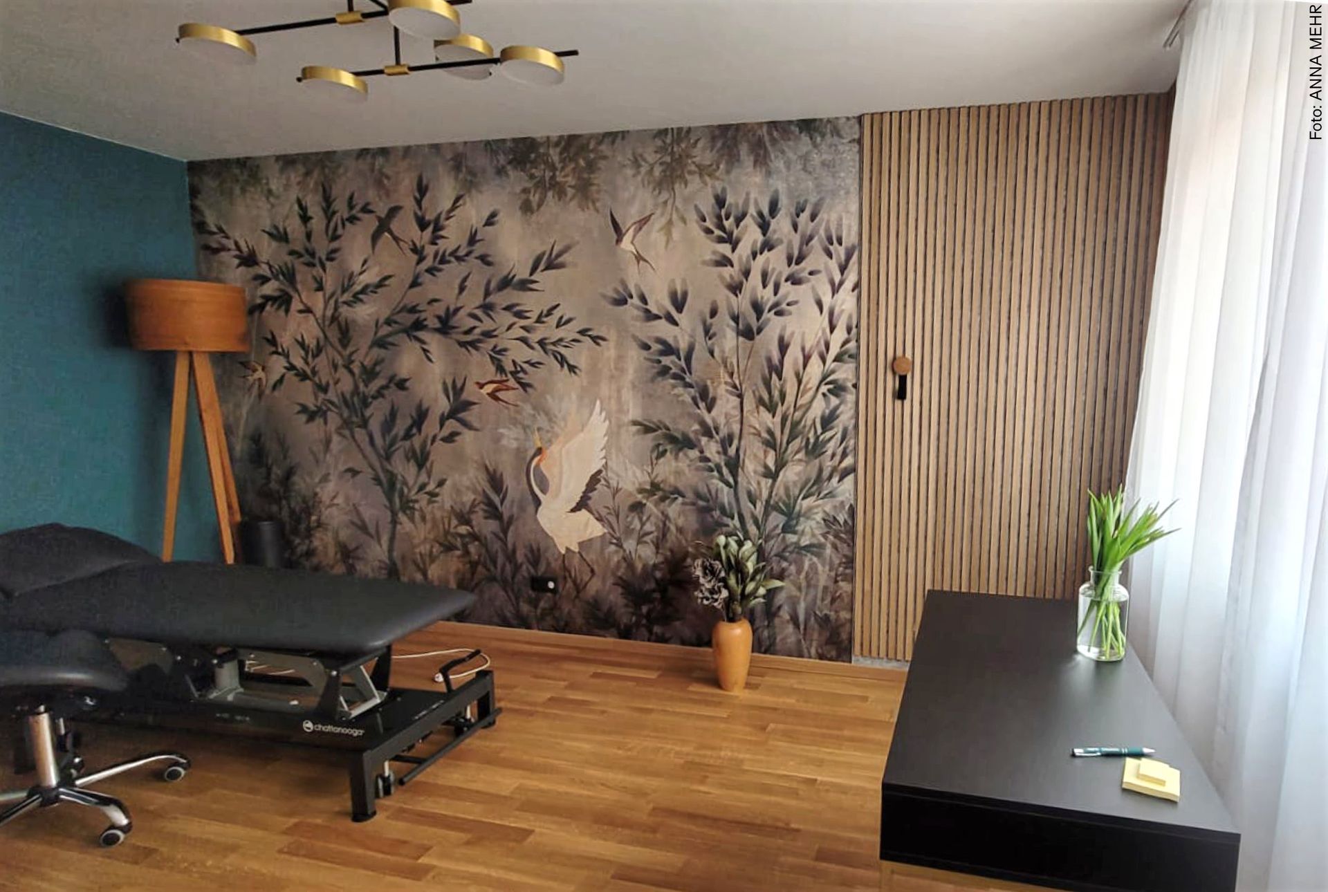 Interior Design für Physiotherapie-Praxis mit floraler WOW-Tapete, Akustikpaneelen aus Holz und Filz sowie warmen Goldakzenten