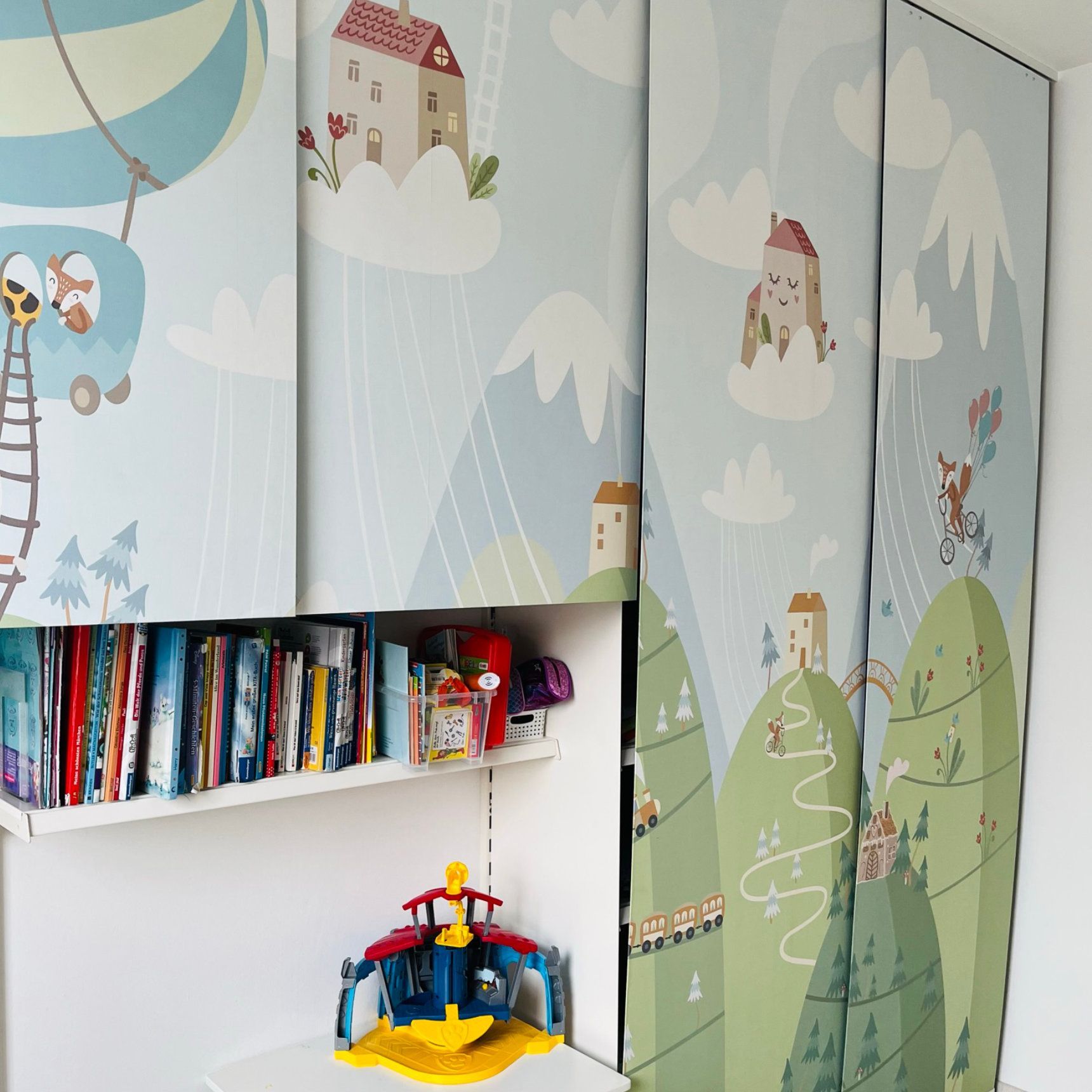 Wartezimmer mit zwei türkisfarbenen Stühlen, hölzerner Wanddekoration und einem Fenster mit grauen Vorhängen.