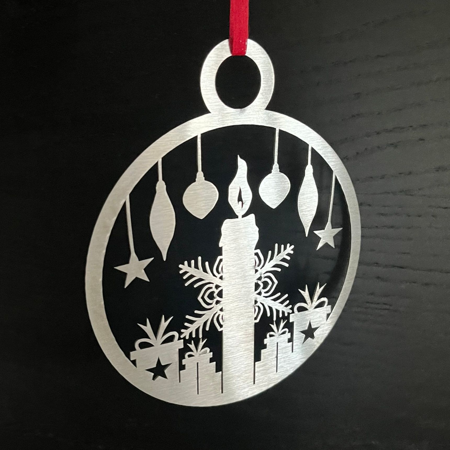 Silberner Weihnachtsschmuck mit Kerze, Schneeflocken, Geschenken und hängenden Dekorationen.