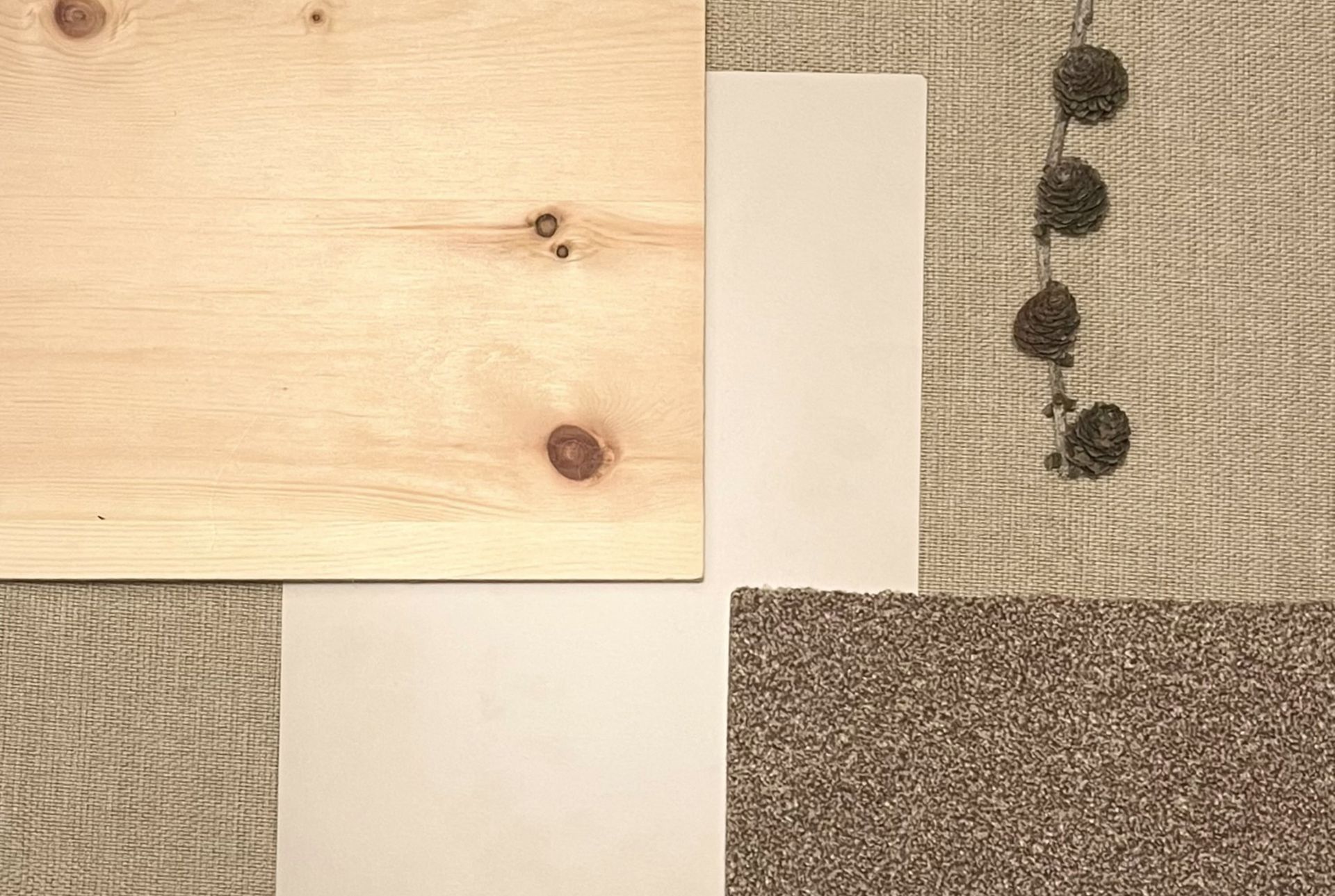 Holzbrett, weiße Fliesen, brauner Teppich und Jutesackstoff, dazu hängende Dekokugeln.