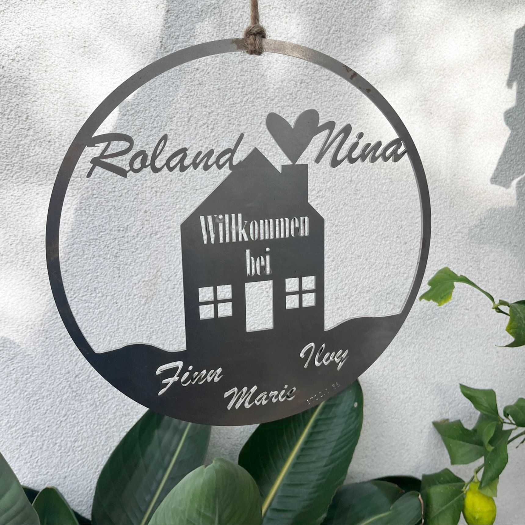 Metal sign: circle with house silhouette, names, 