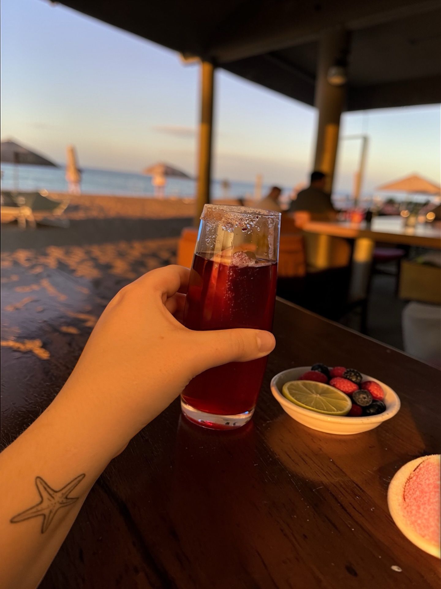 Hand holding a red drink.