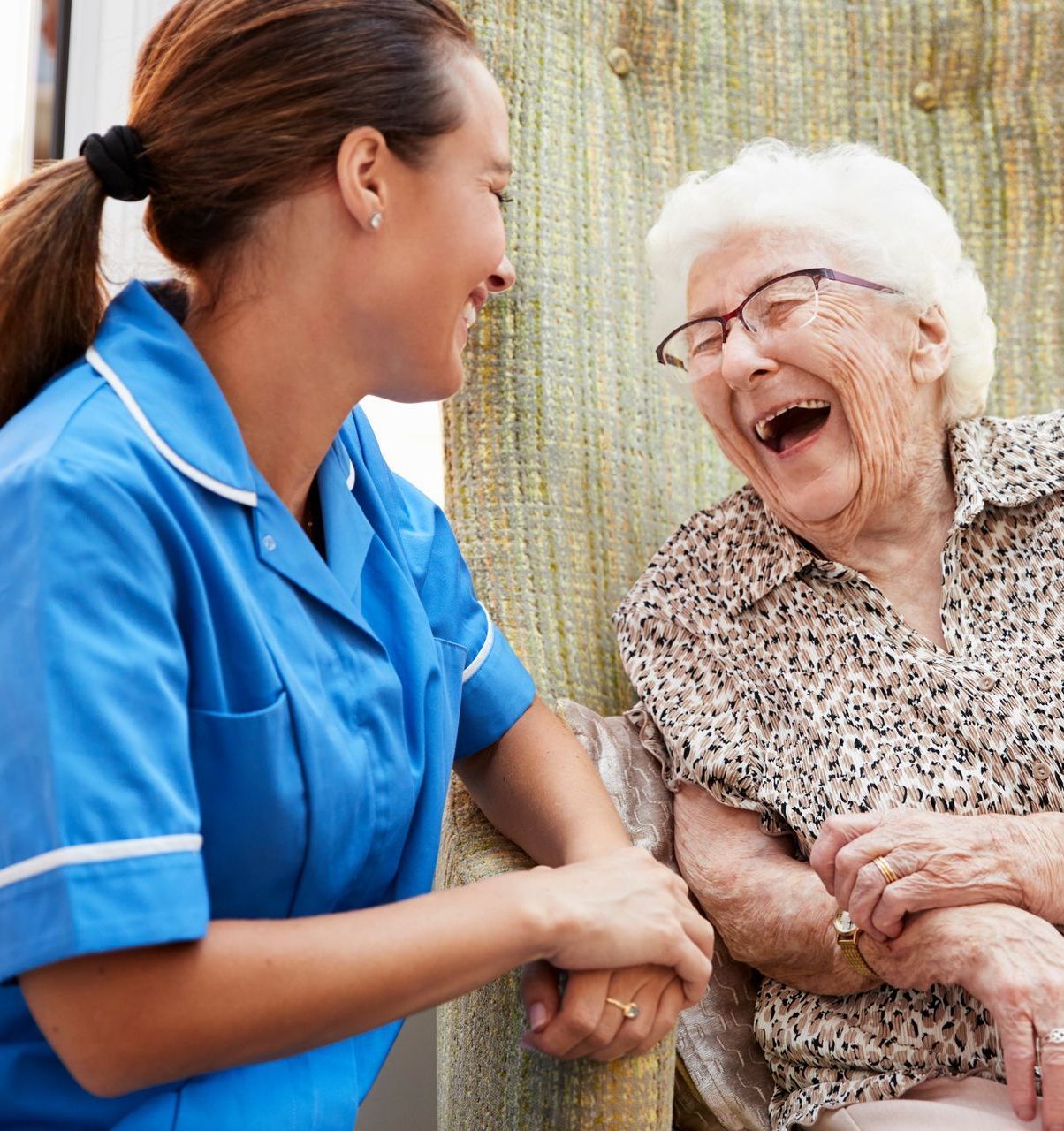 An elderly woman connecting with a nursing home worker