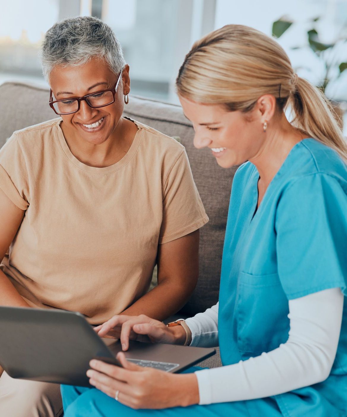 A nursing home worker presenting to a colleague on a laptop