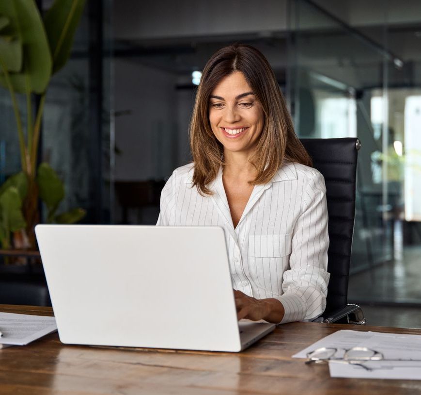A woman typing on a laptop at a facility