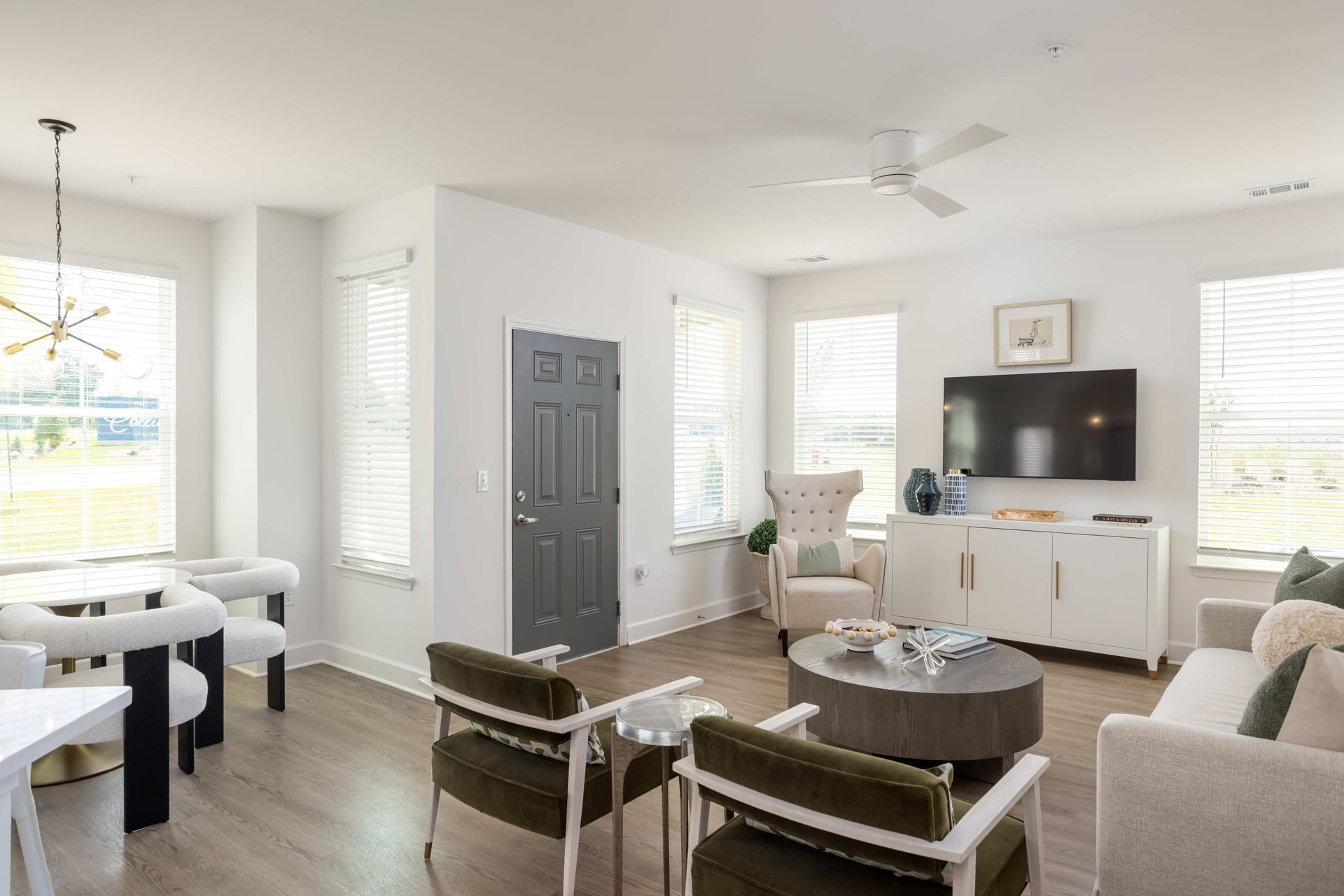 Bedroom with a bed, nightstand, and chair. Neutral colors with blue accents, white walls, and a window.