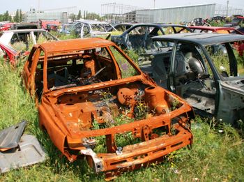 A bunch of rusted cars are sitting in a field