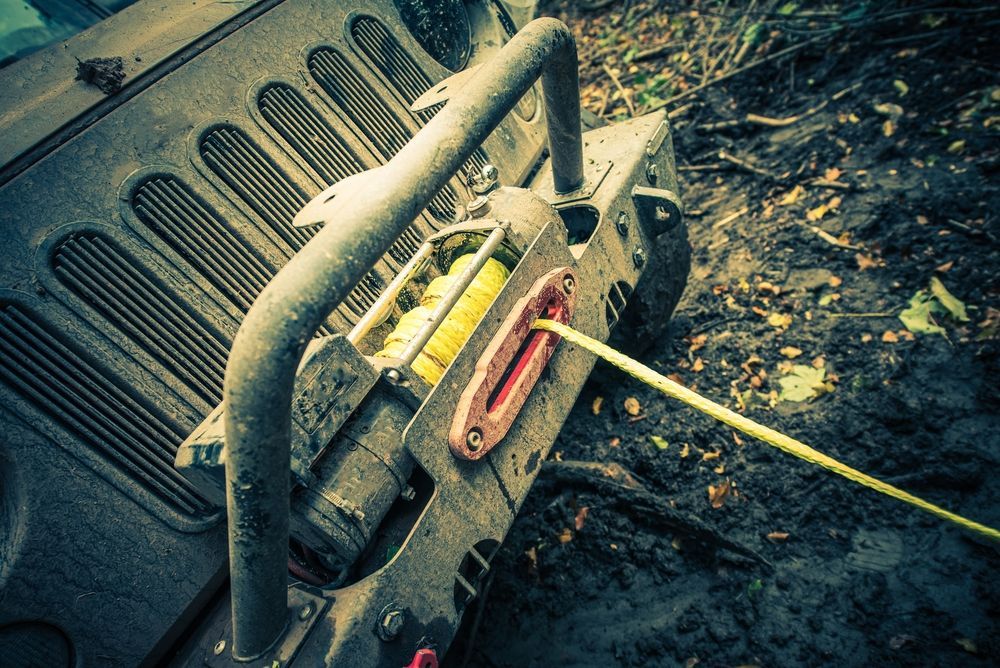 A jeep with a winch attached to the front bumper.