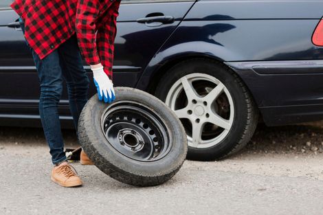 A man is changing a tire on a car.