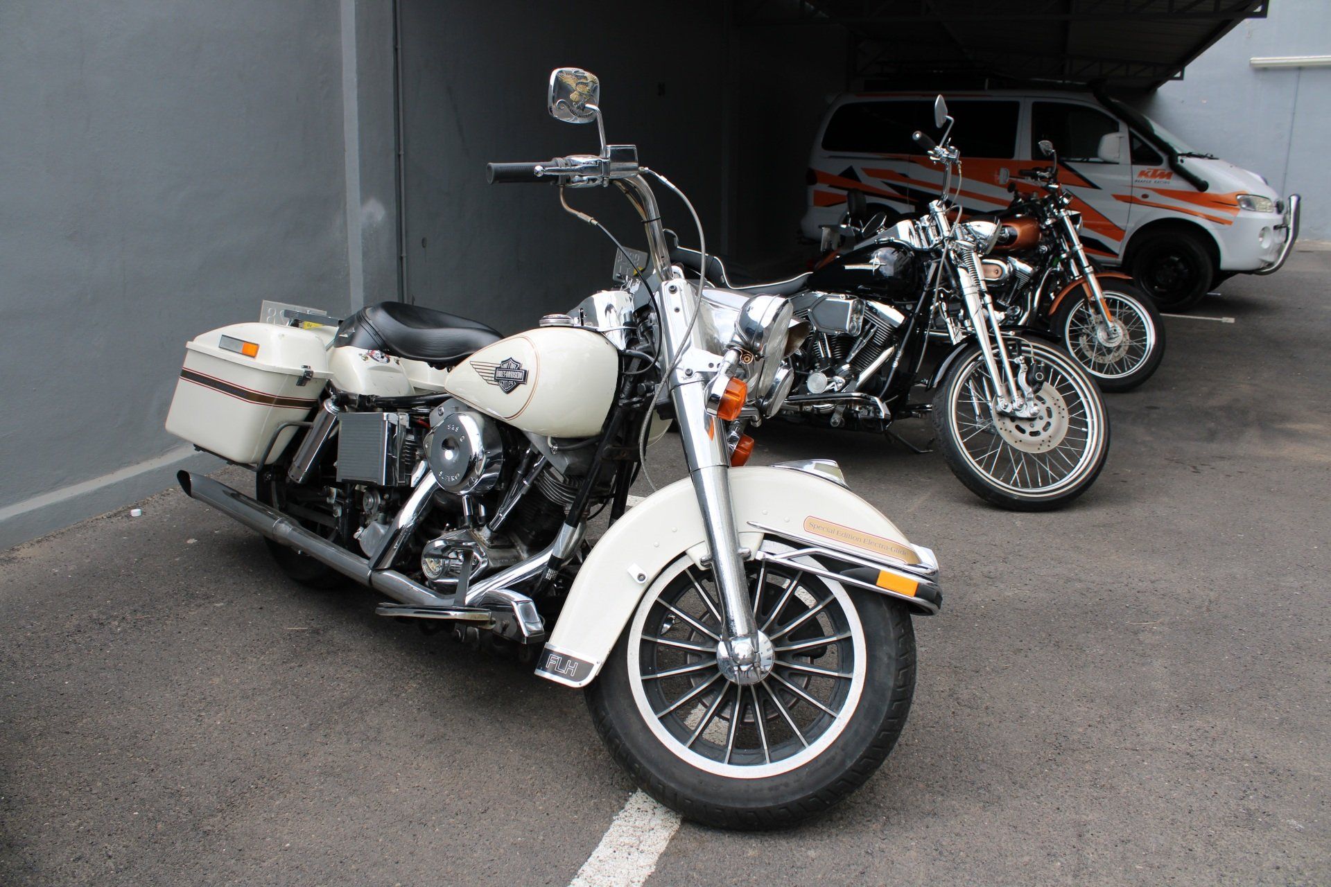 Three harley davidson motorcycles are parked in a parking lot
