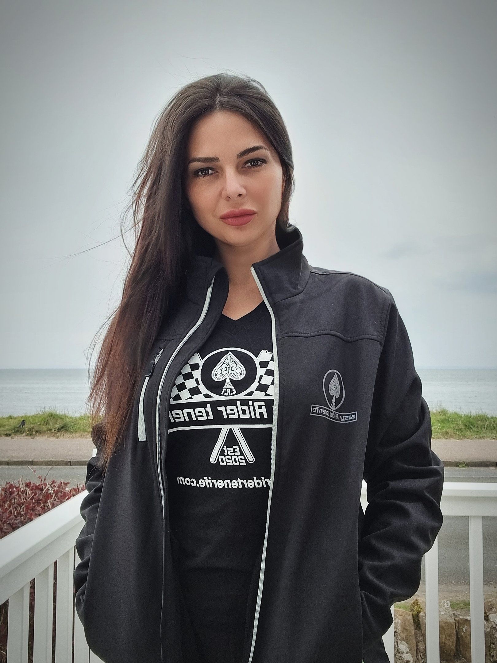 A woman wearing a black jacket and a black t-shirt with a spade on it