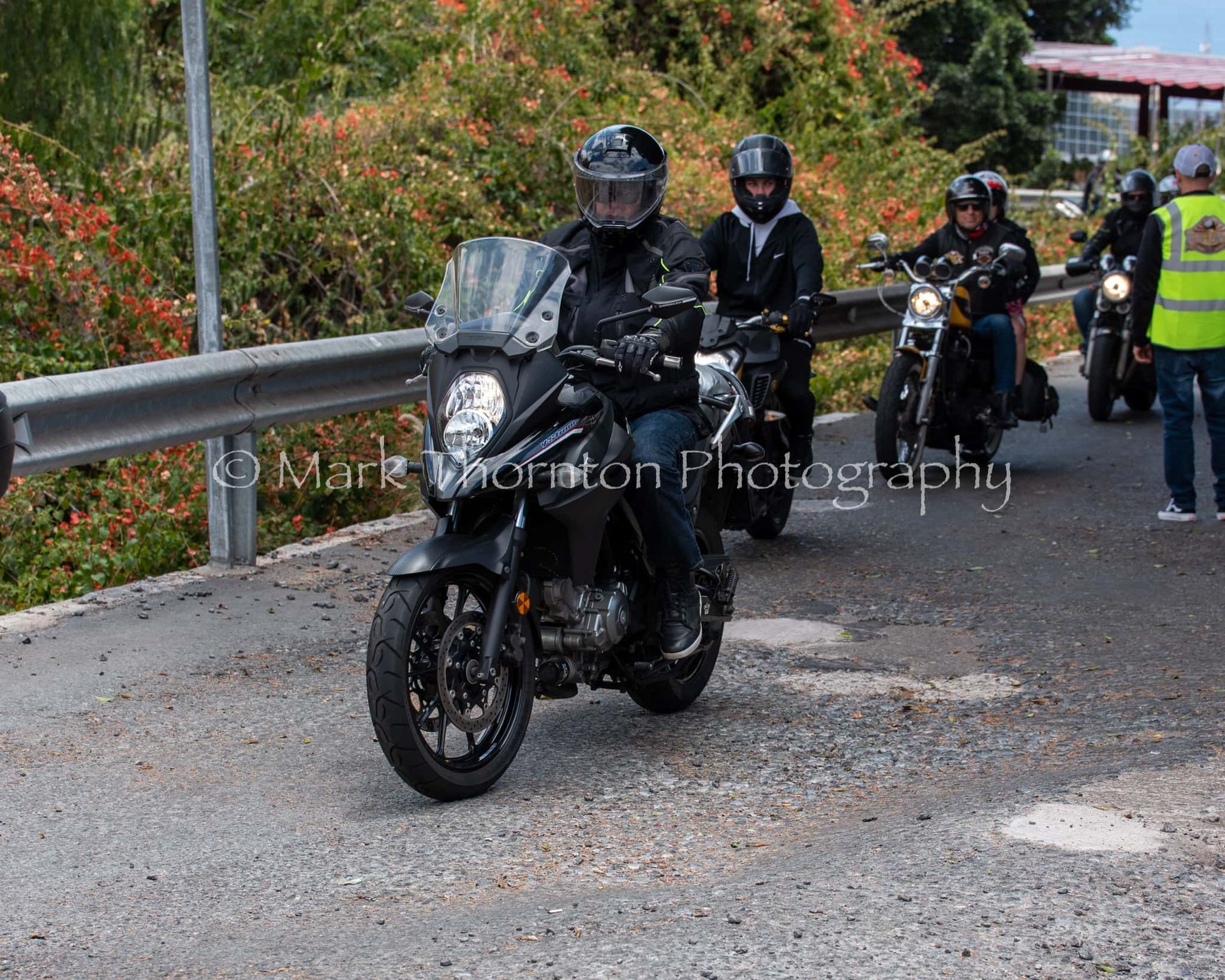 A group of people are riding motorcycles down a road ..