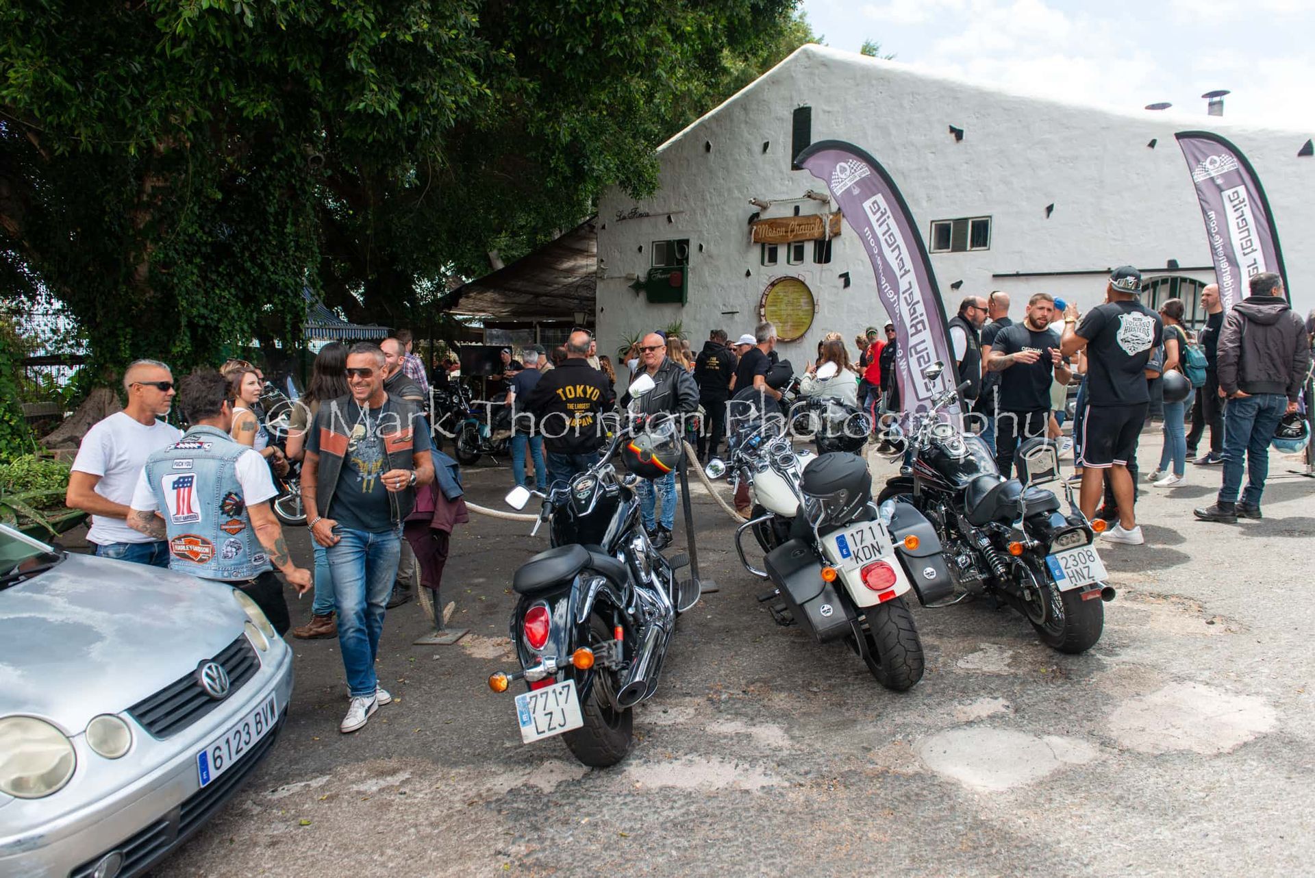 A group of people standing around motorcycles in front of a building