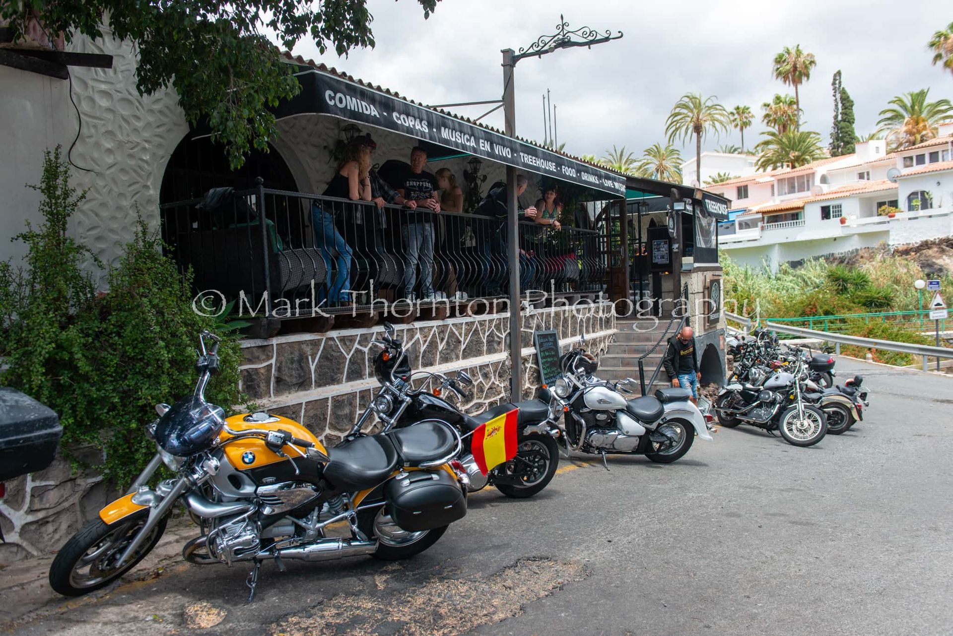 A row of motorcycles parked in front of a restaurant
