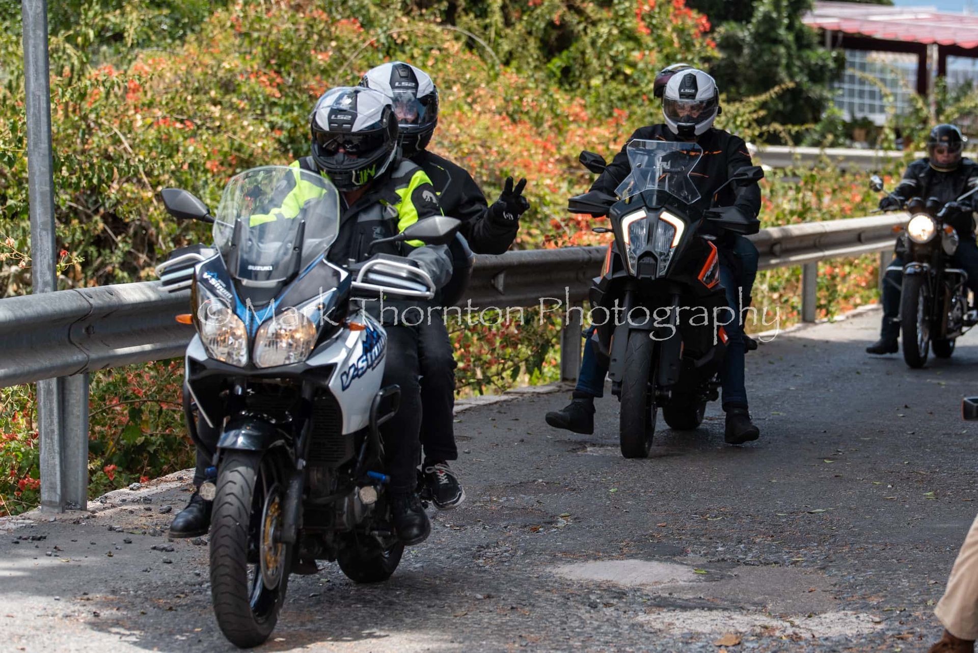 A group of people are riding motorcycles down a road.