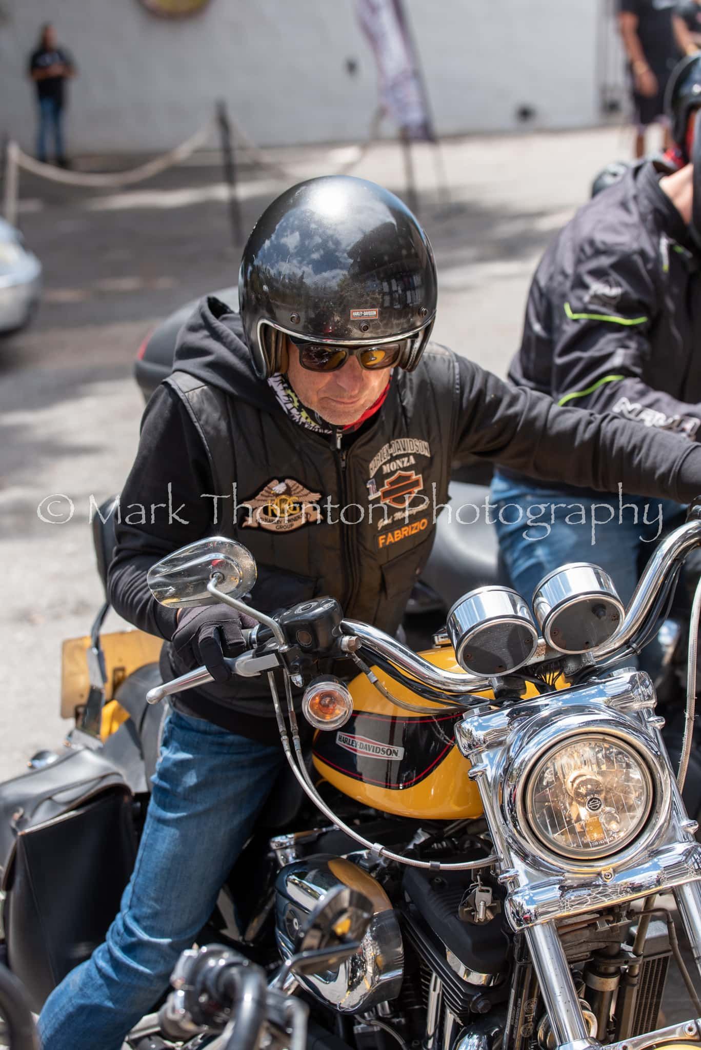 A man wearing a helmet and sunglasses is riding a motorcycle.