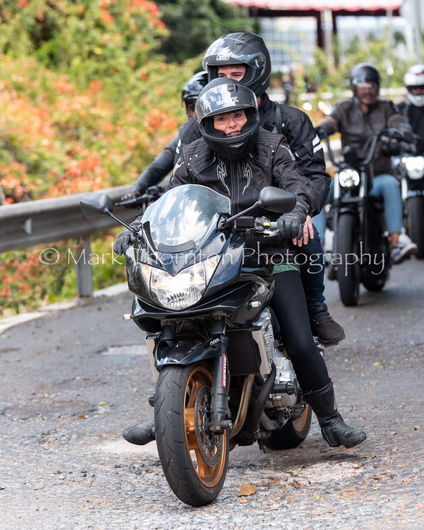 A group of people are riding motorcycles down a road.
