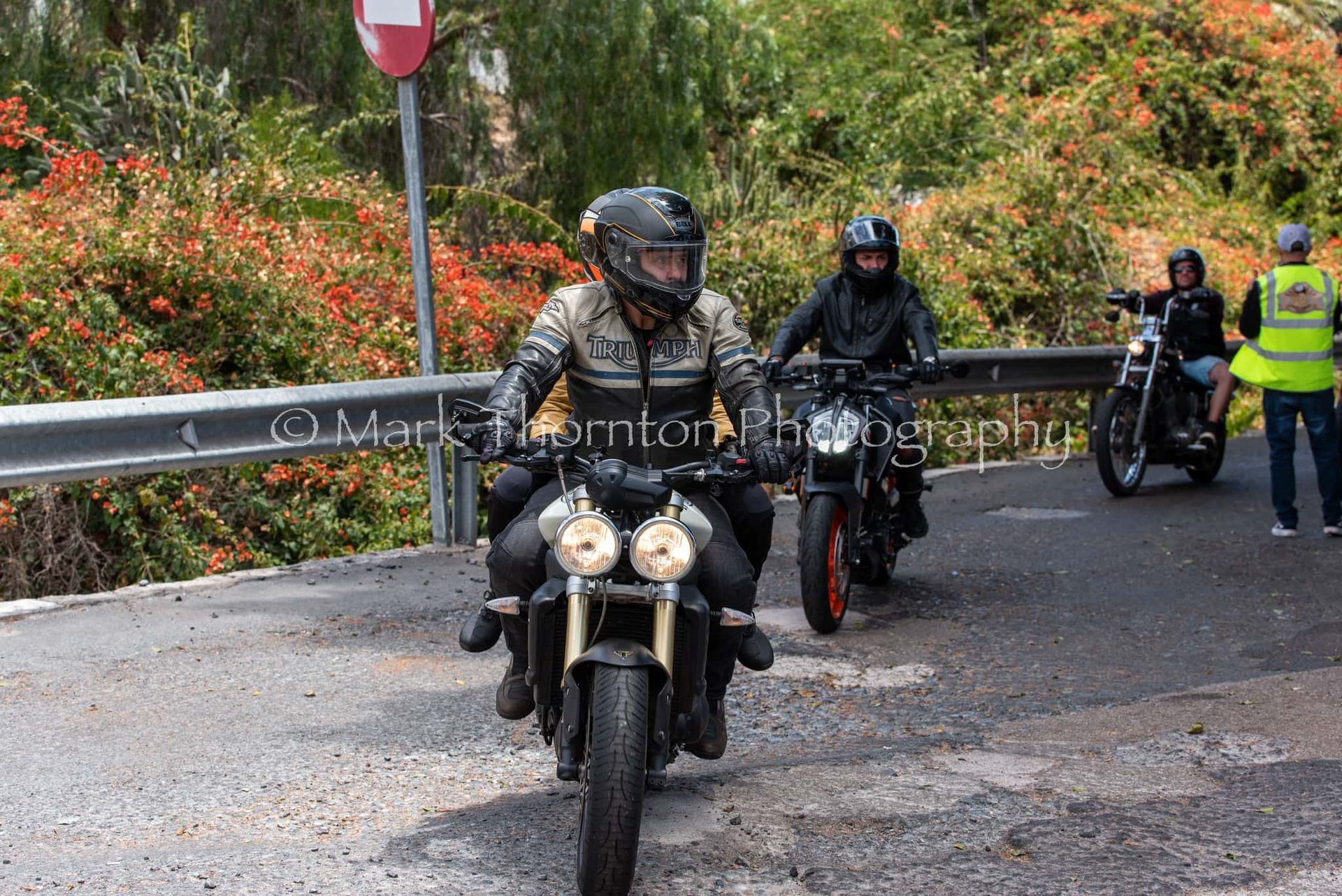 A group of people are riding motorcycles down a road.