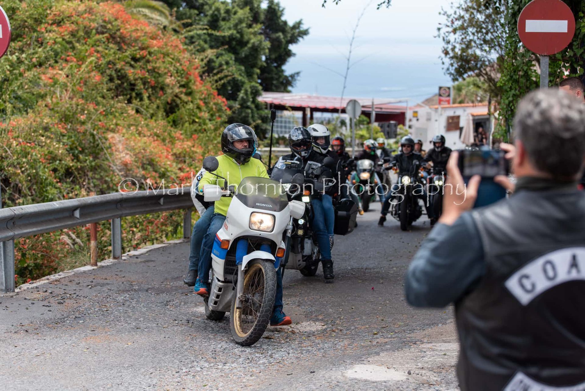 A man taking a picture of a group of people riding motorcycles