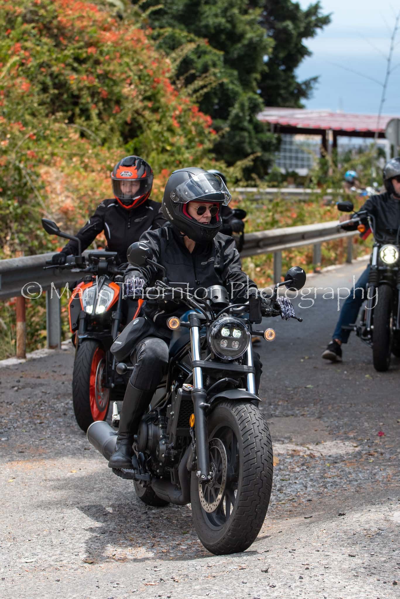 A group of people are riding motorcycles down a road.