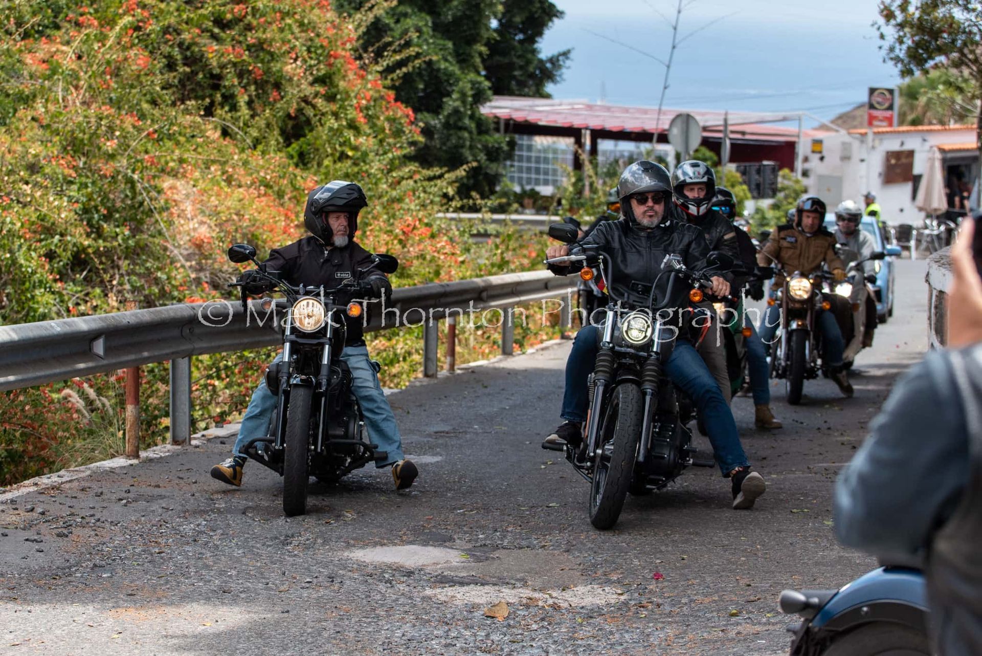 A group of people are riding motorcycles down a road.