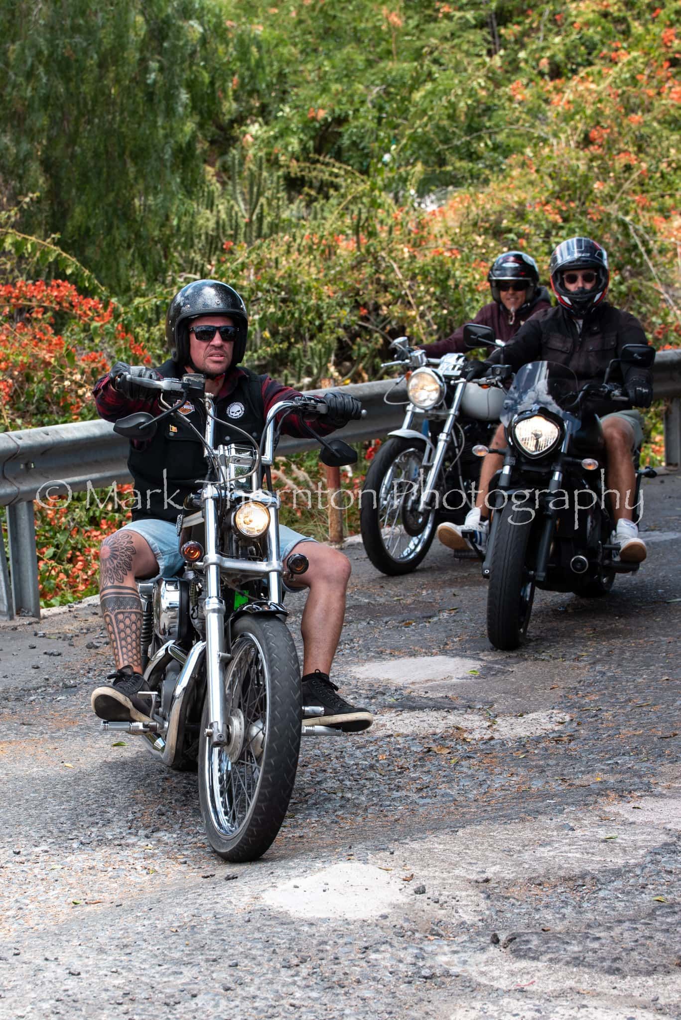 A group of people are riding motorcycles down a road.