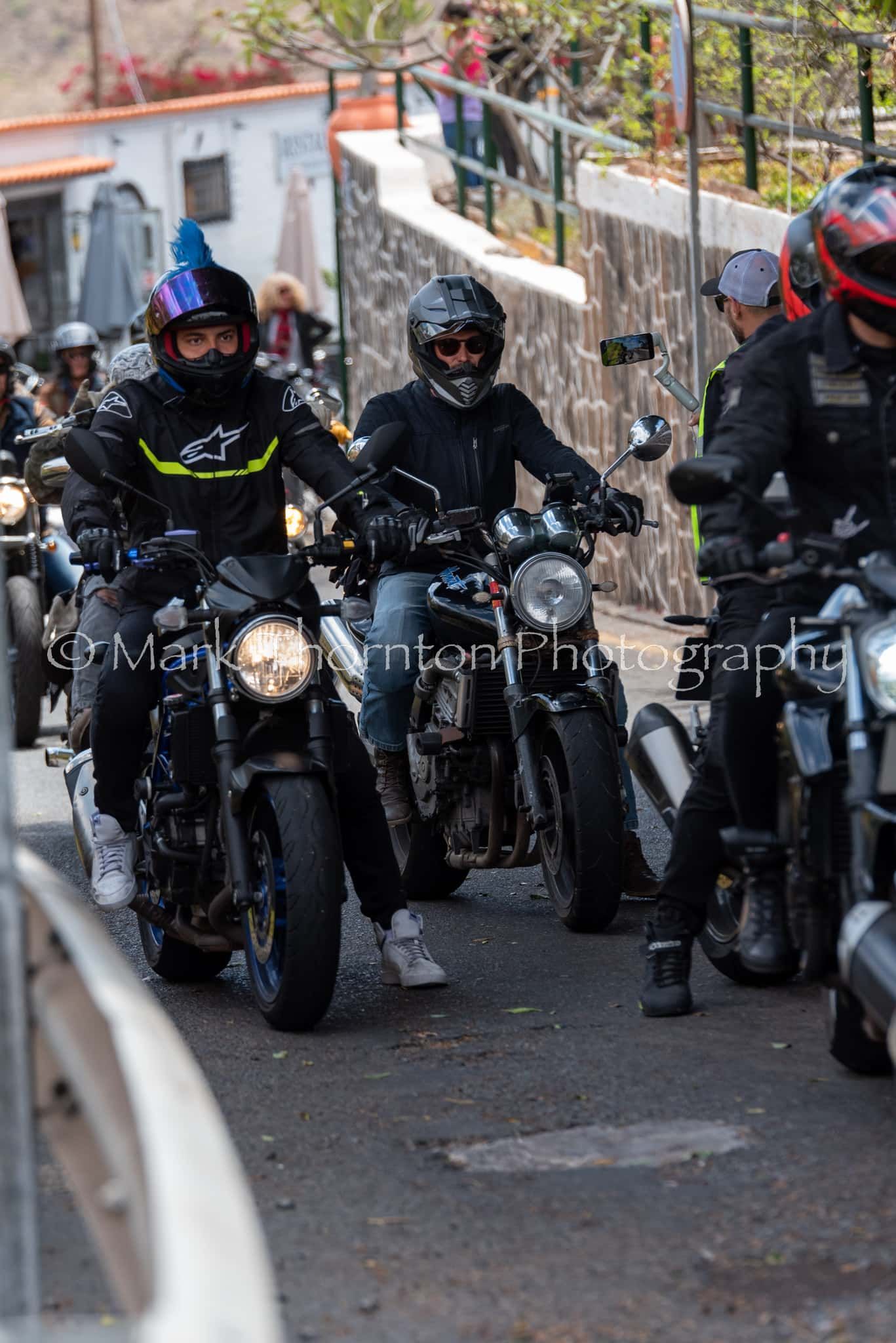 A group of people are riding motorcycles down a street.