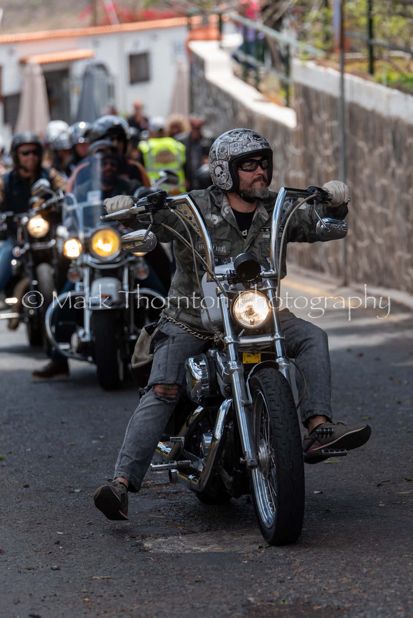 A group of people are riding motorcycles down a street.