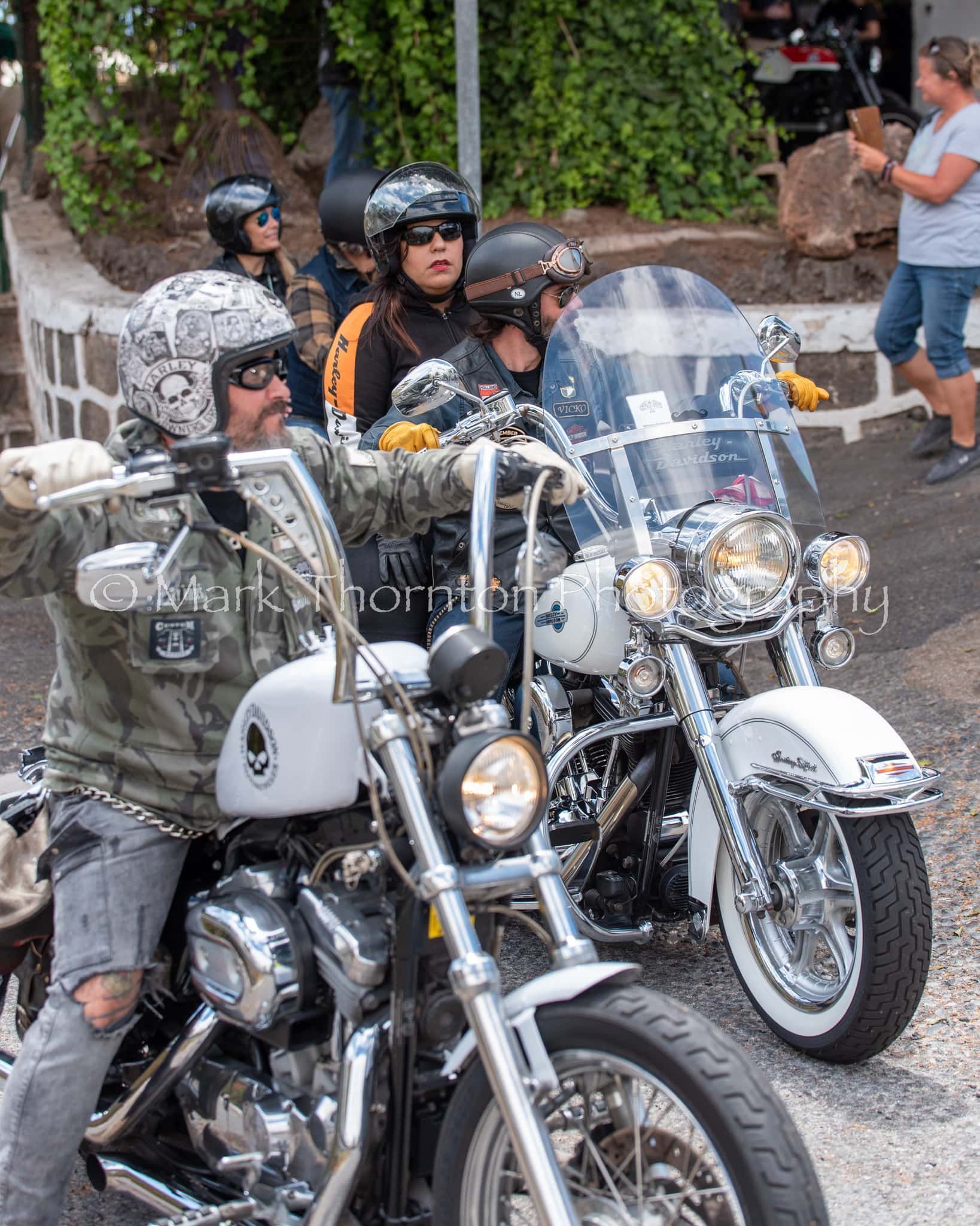 A group of people are riding motorcycles down a street.
