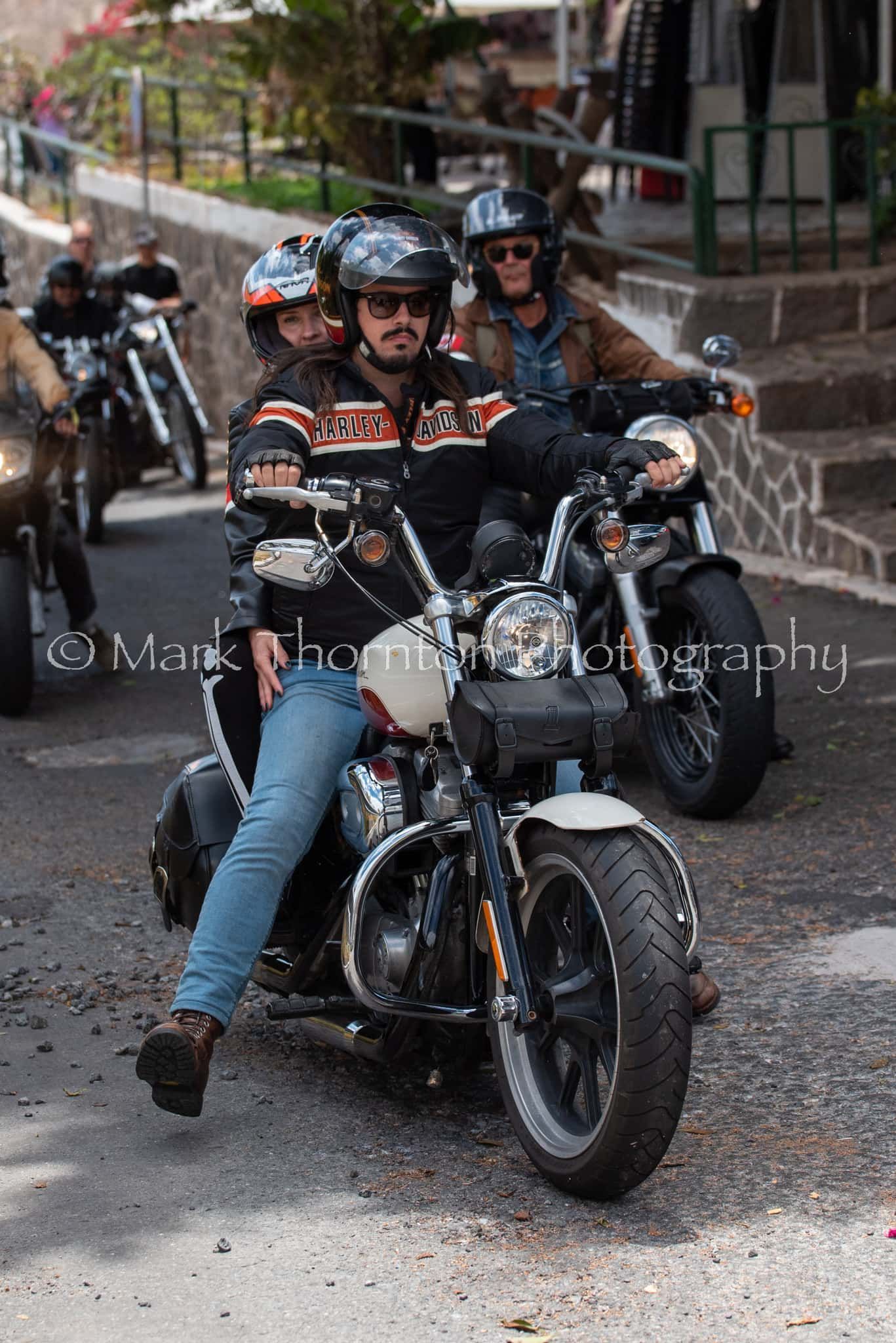 A group of people are riding motorcycles down a street.