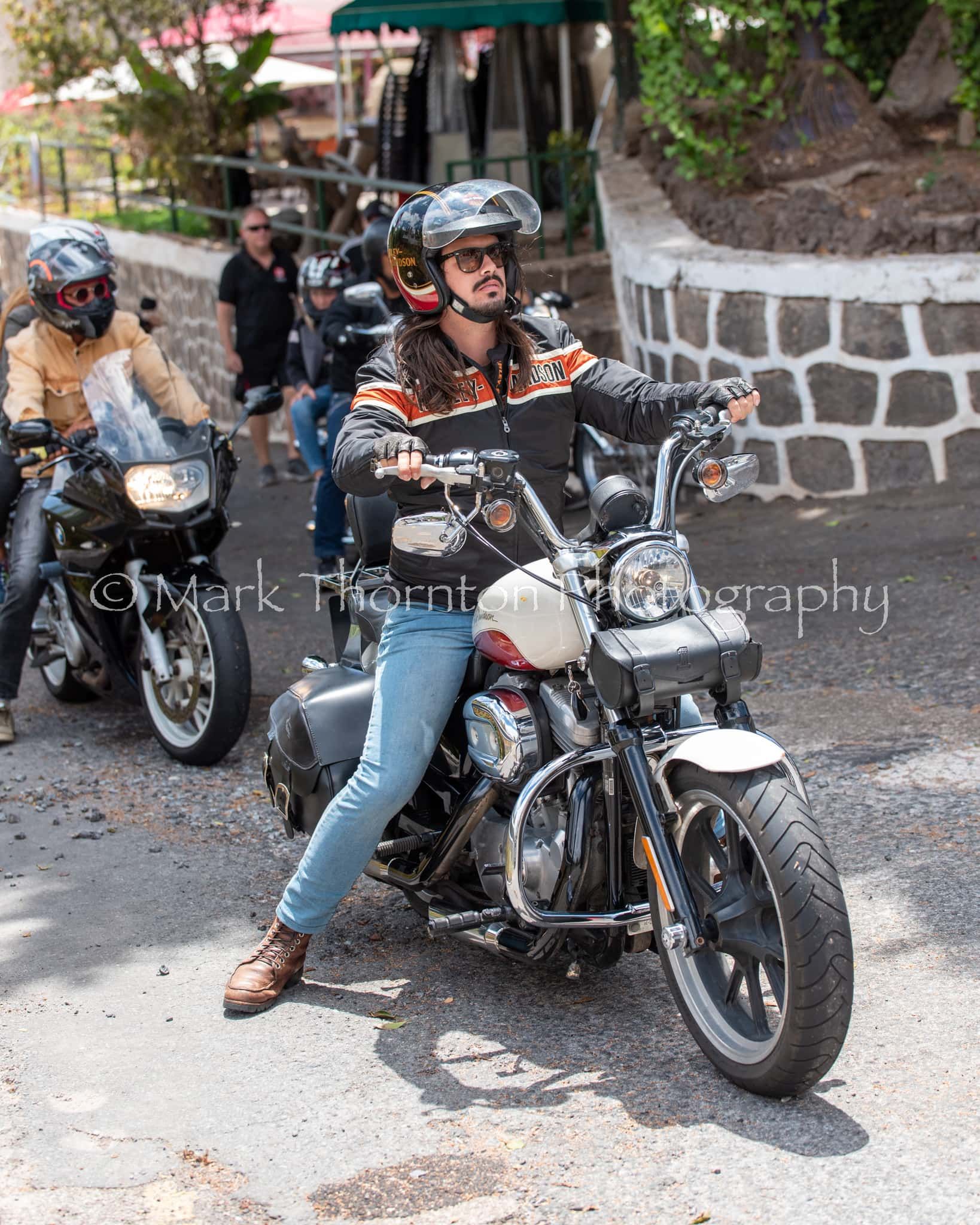 A group of people are riding motorcycles down a street.