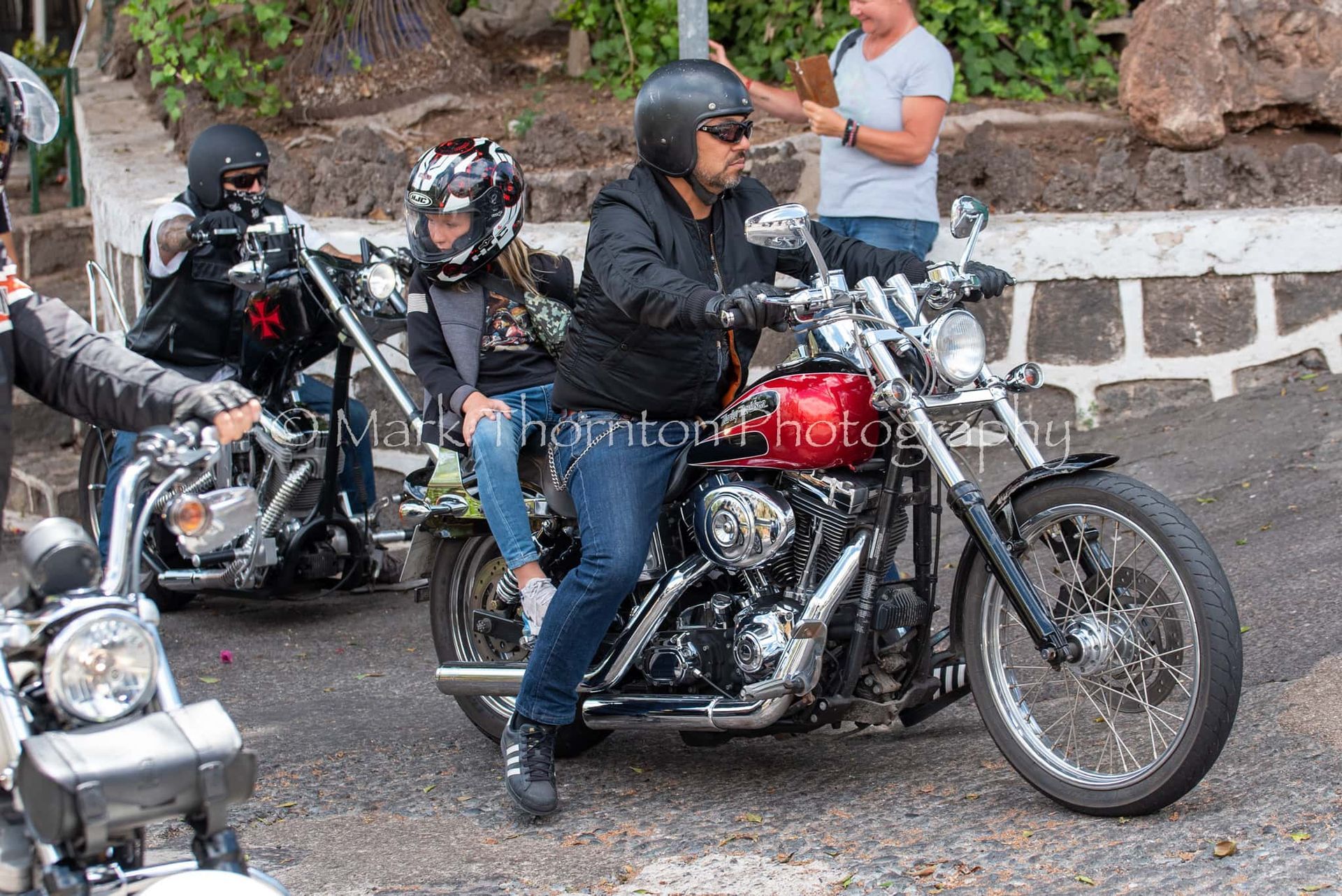 A group of people are riding motorcycles down a street.