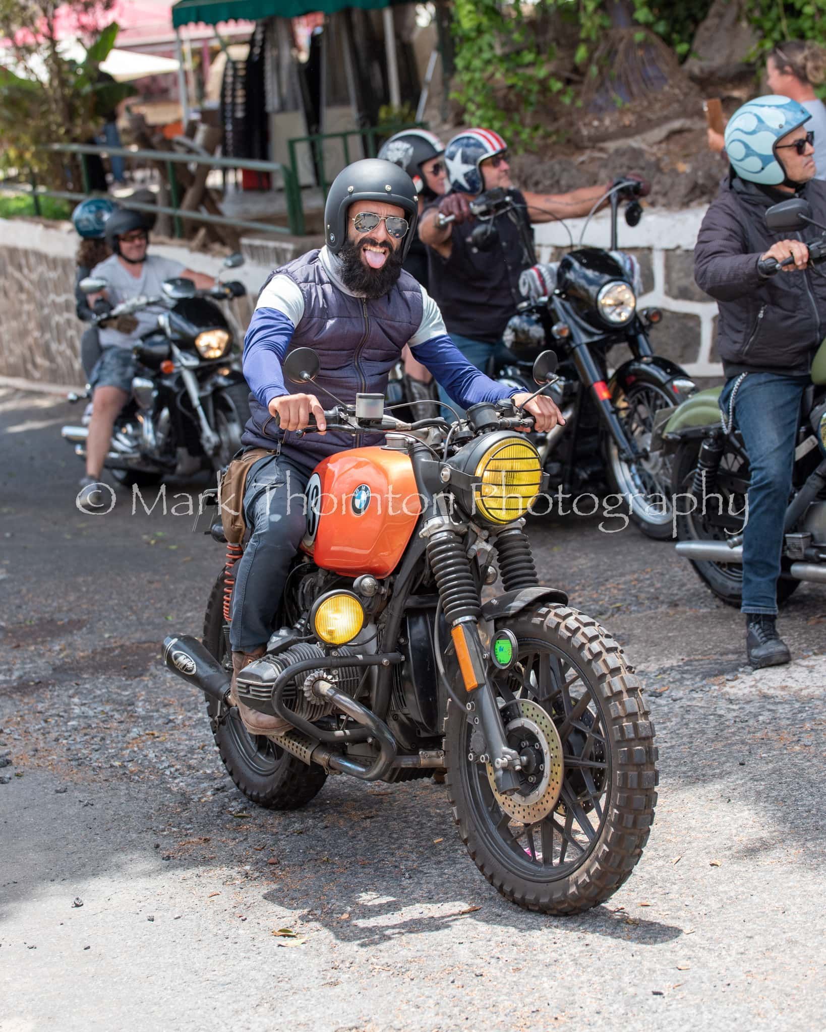 A group of people are riding motorcycles down a street.