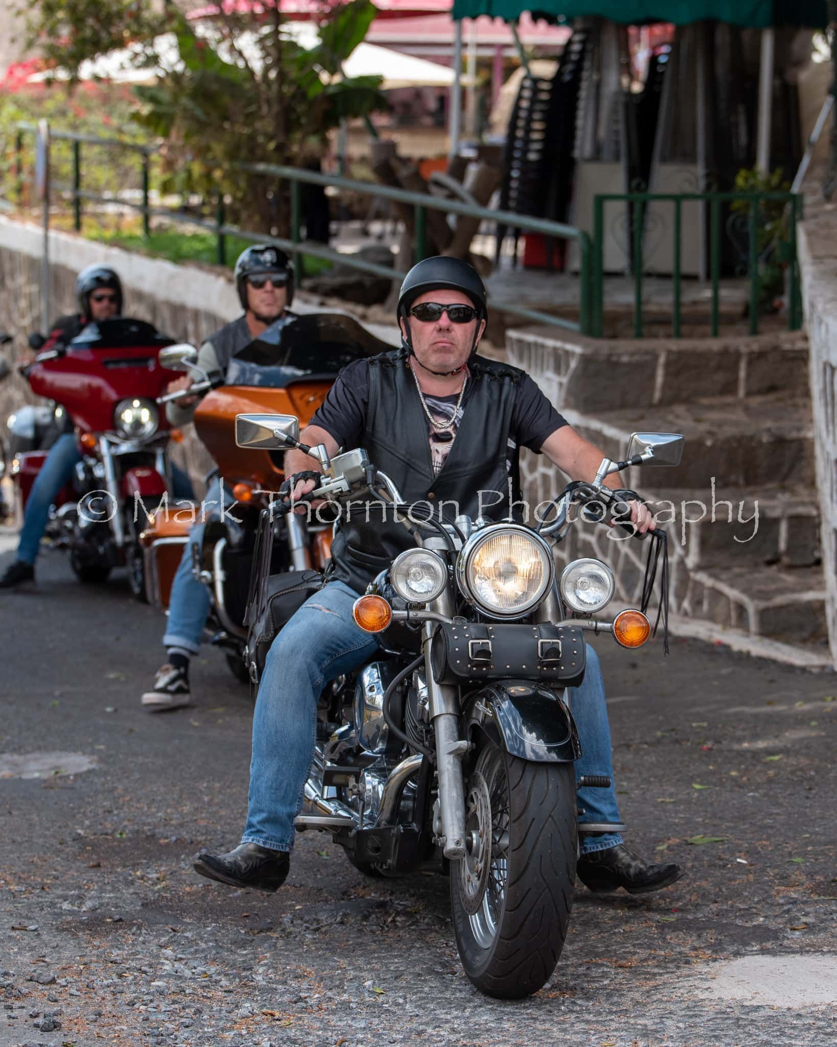 A man is riding a harley davidson motorcycle on a street