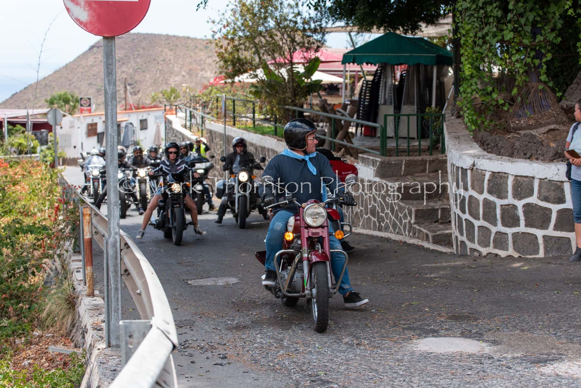 A group of people are riding motorcycles down a road
