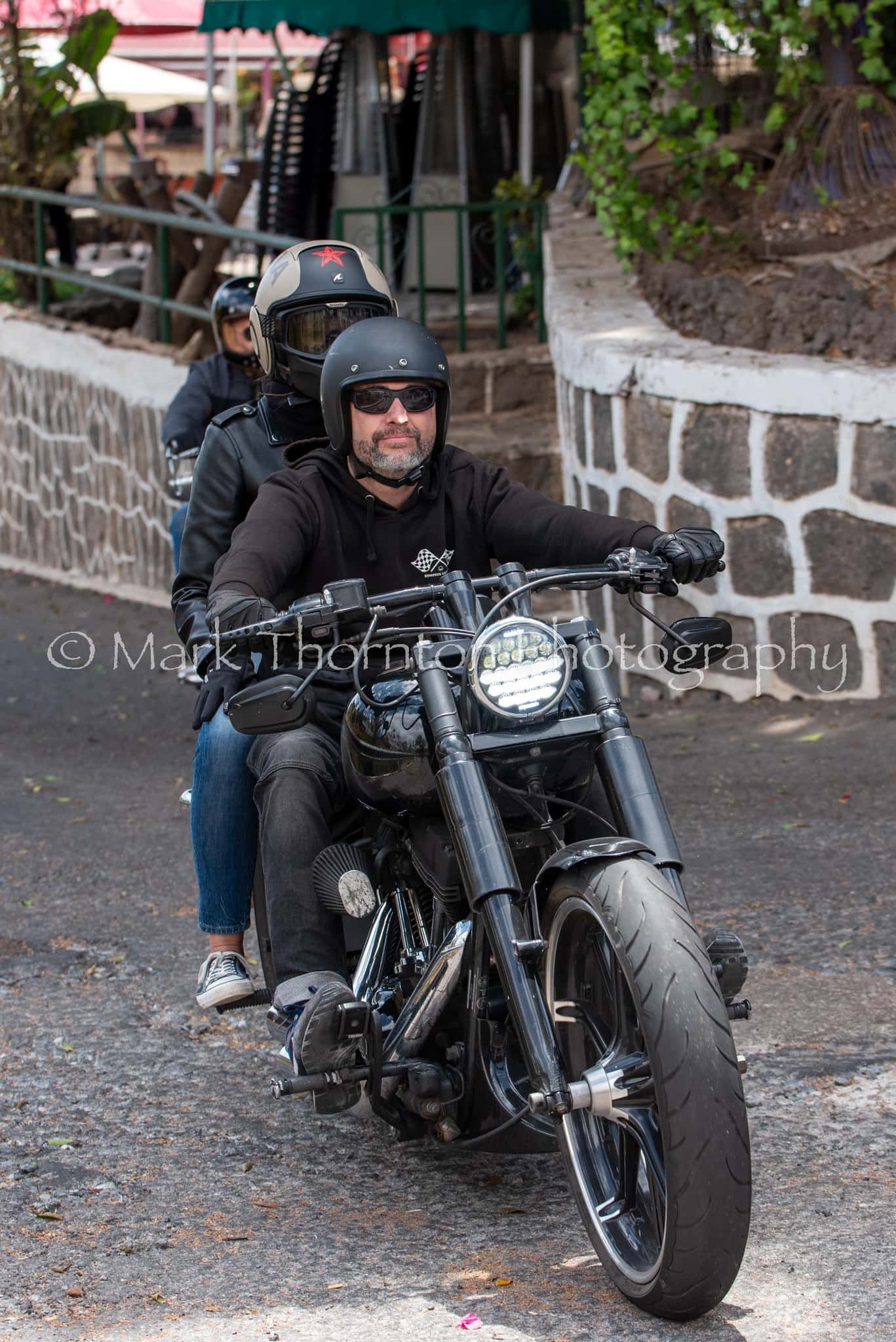 A man is riding a motorcycle with a woman on the back.