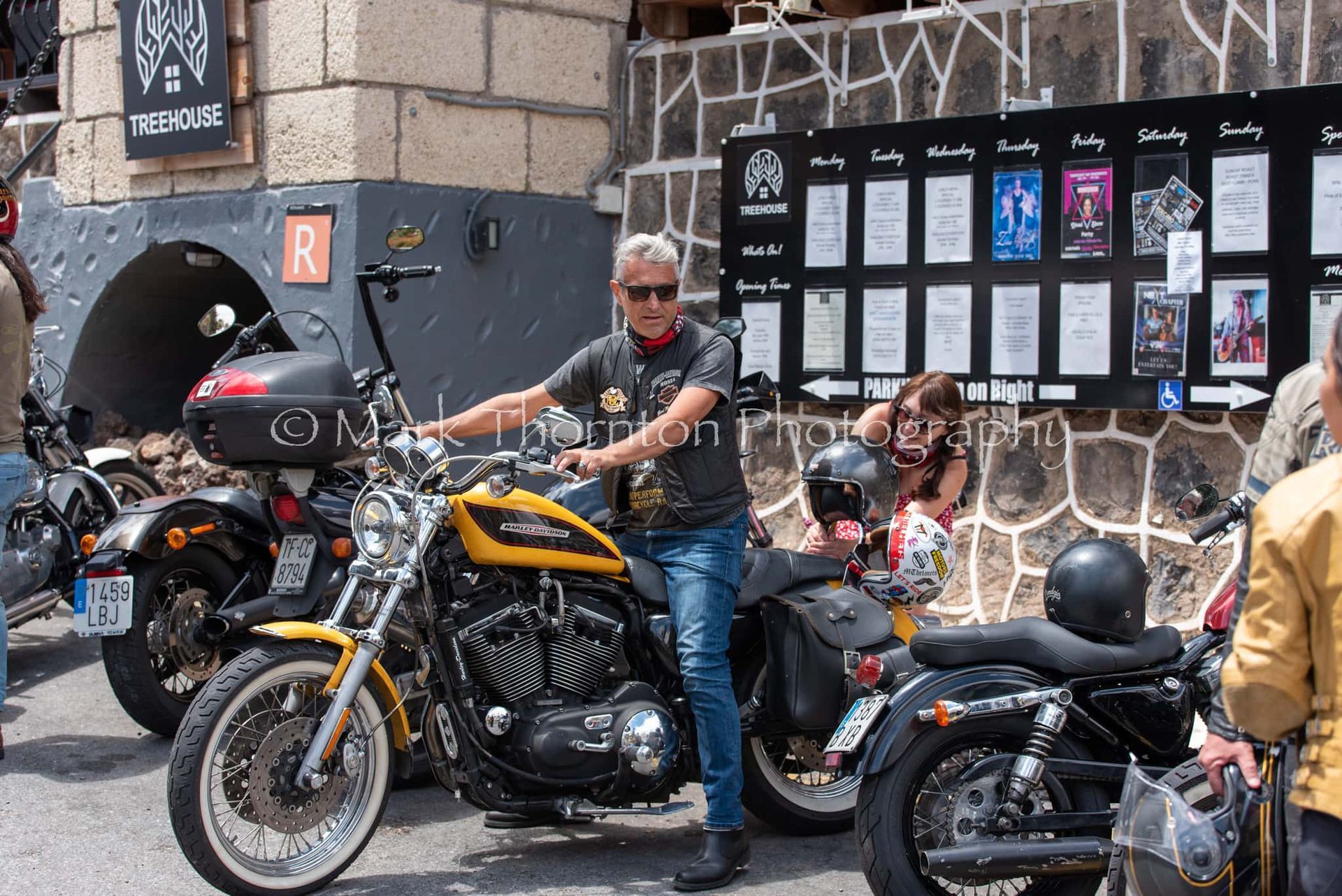 A man is standing next to a harley davidson motorcycle