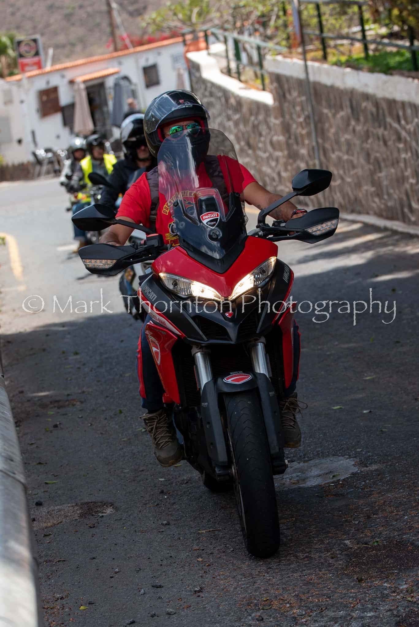 A group of people are riding motorcycles down a street.