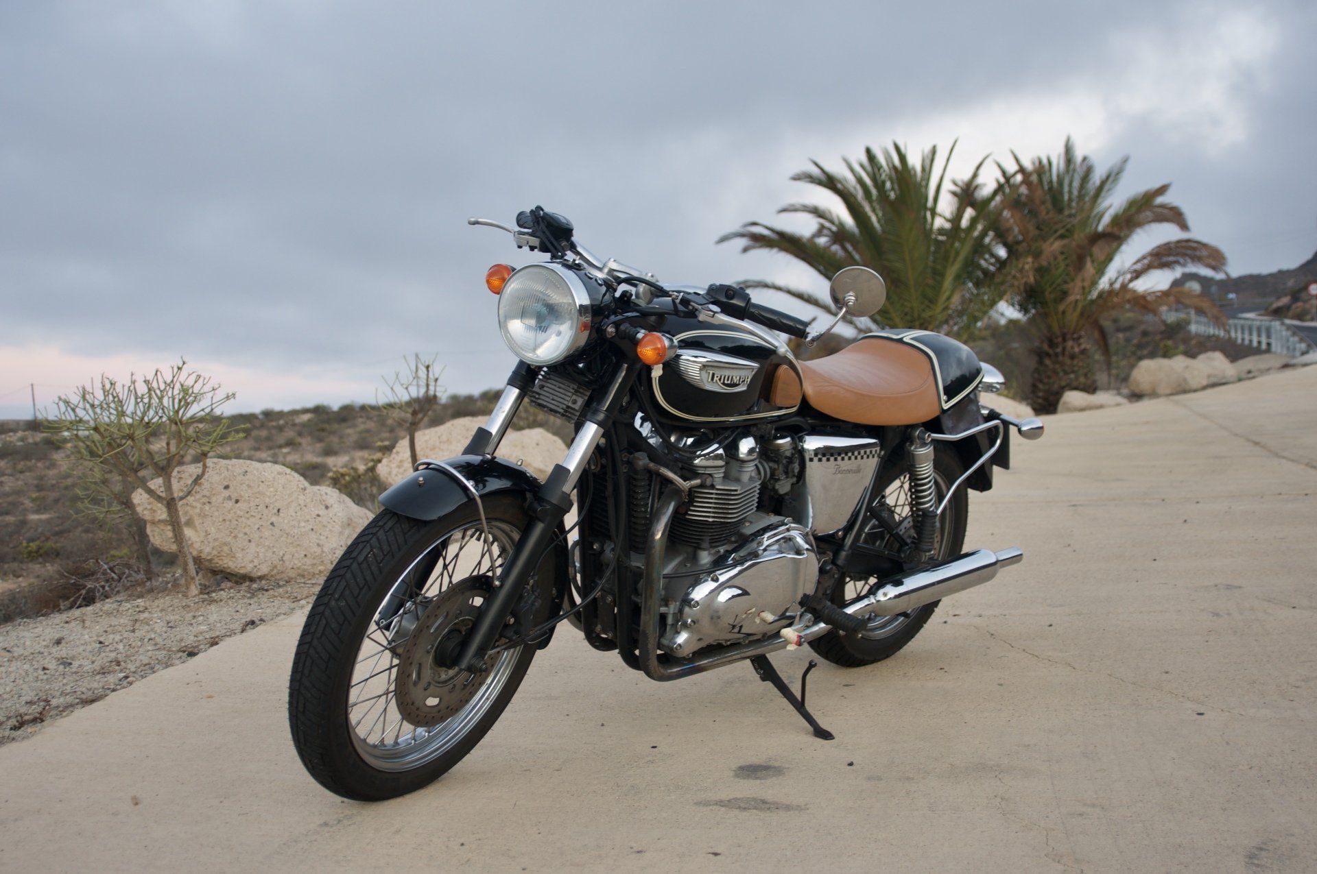 A triumph motorcycle is parked on the side of the road